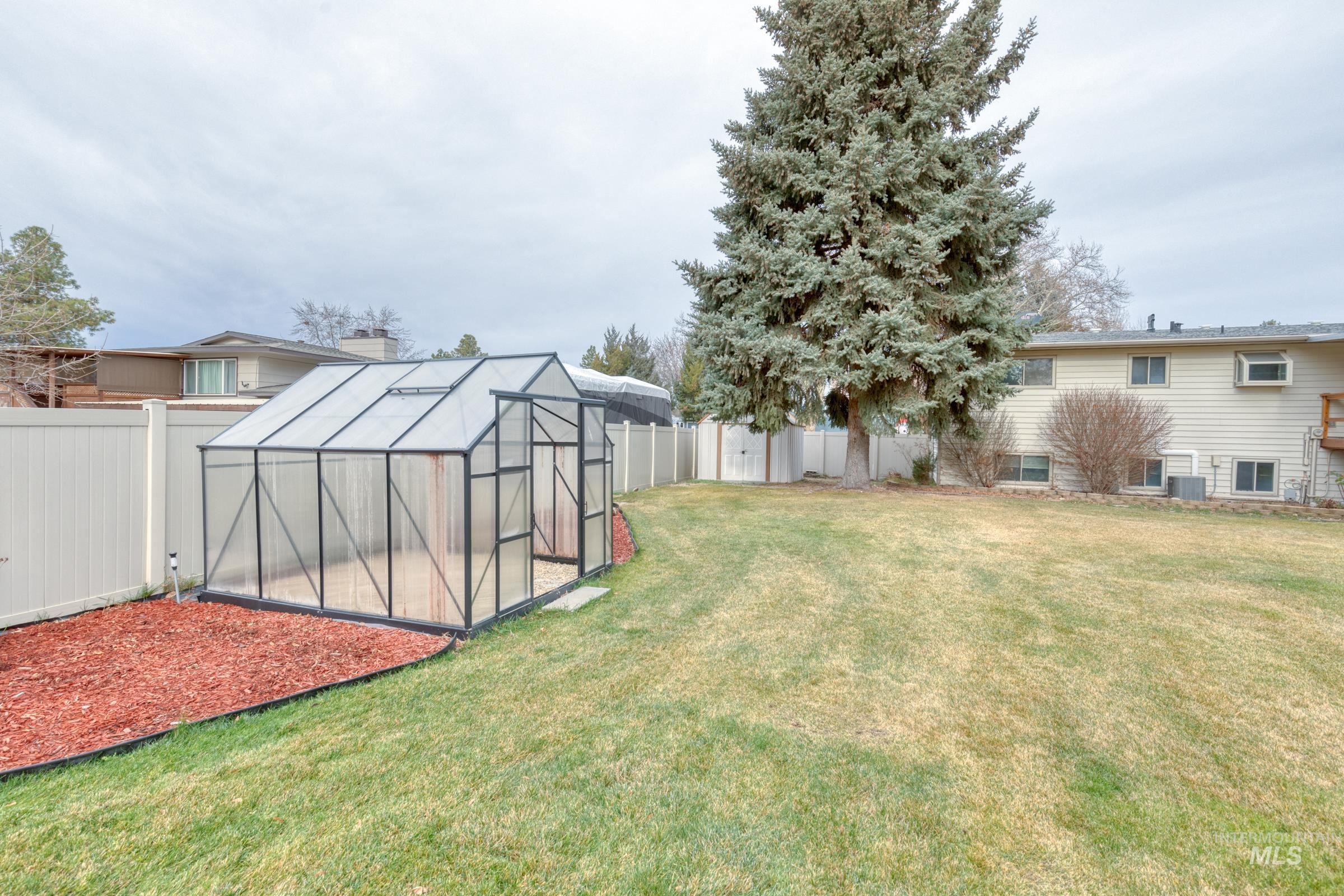 Fenced backyard with an exterior structure and an outbuilding