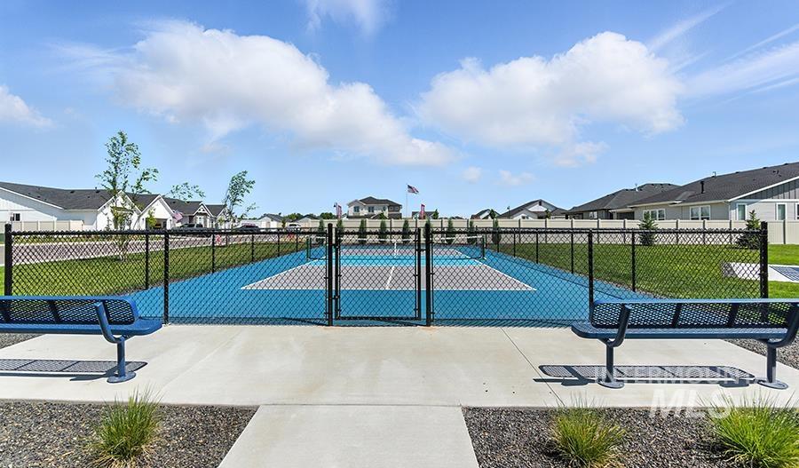 View of basketball court featuring a tennis court, a residential view, and a gate