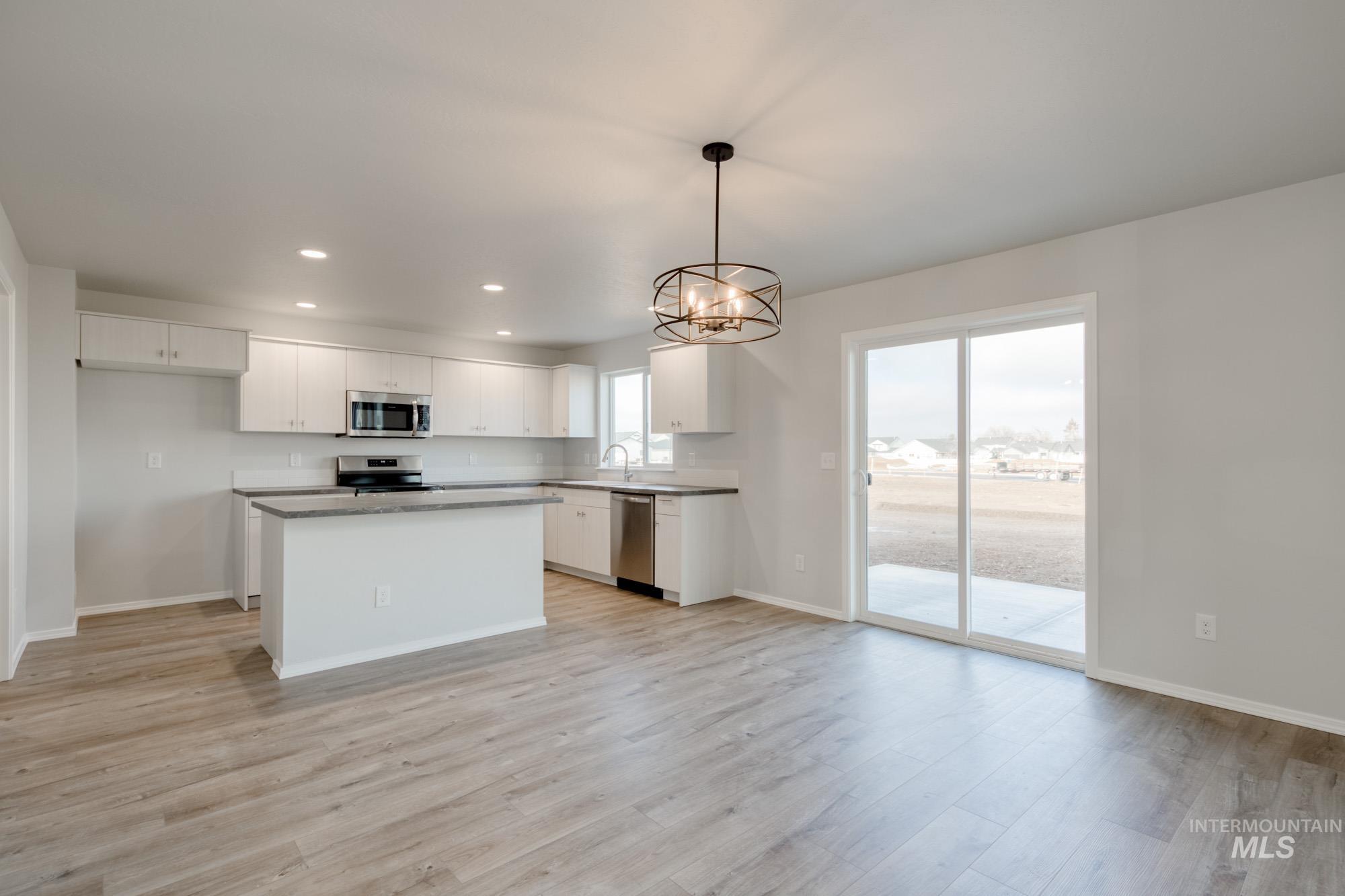 Kitchen with a chandelier, recessed lighting, white cabinetry, a center island, and decorative light fixtures