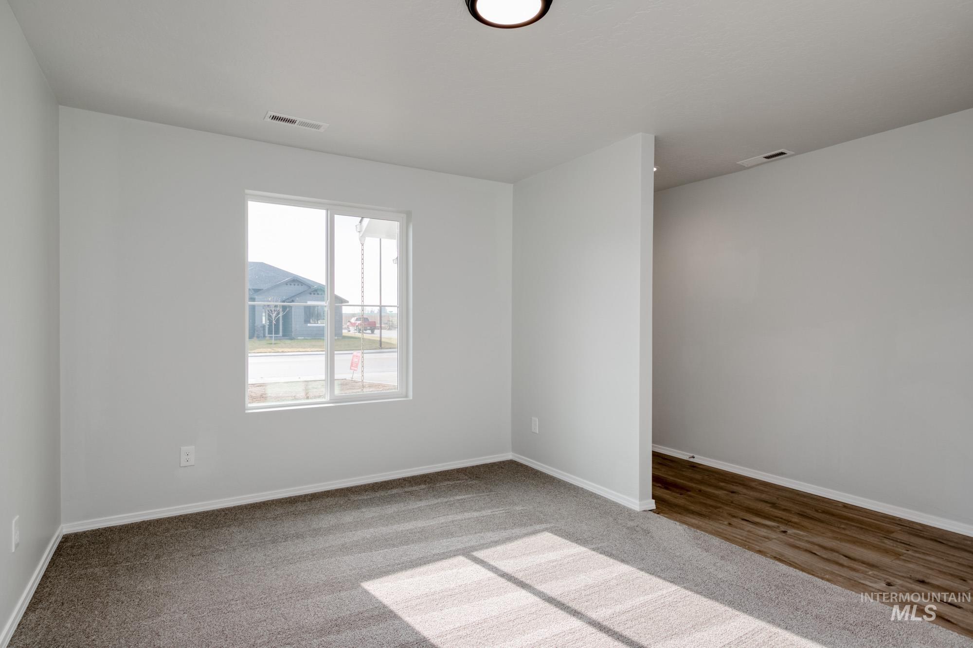 Carpeted empty room featuring baseboards