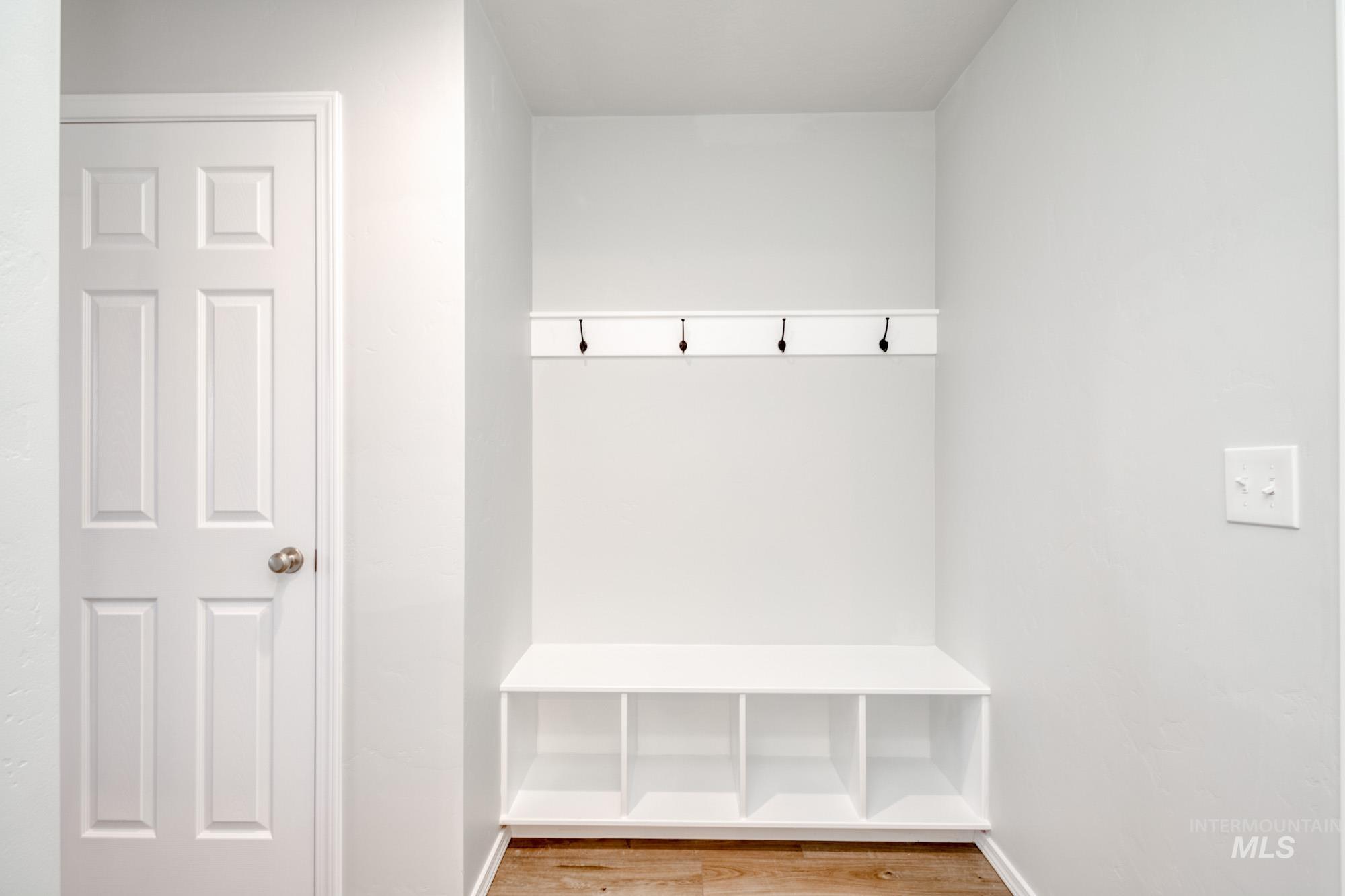 Mudroom with light wood finished floors and baseboards