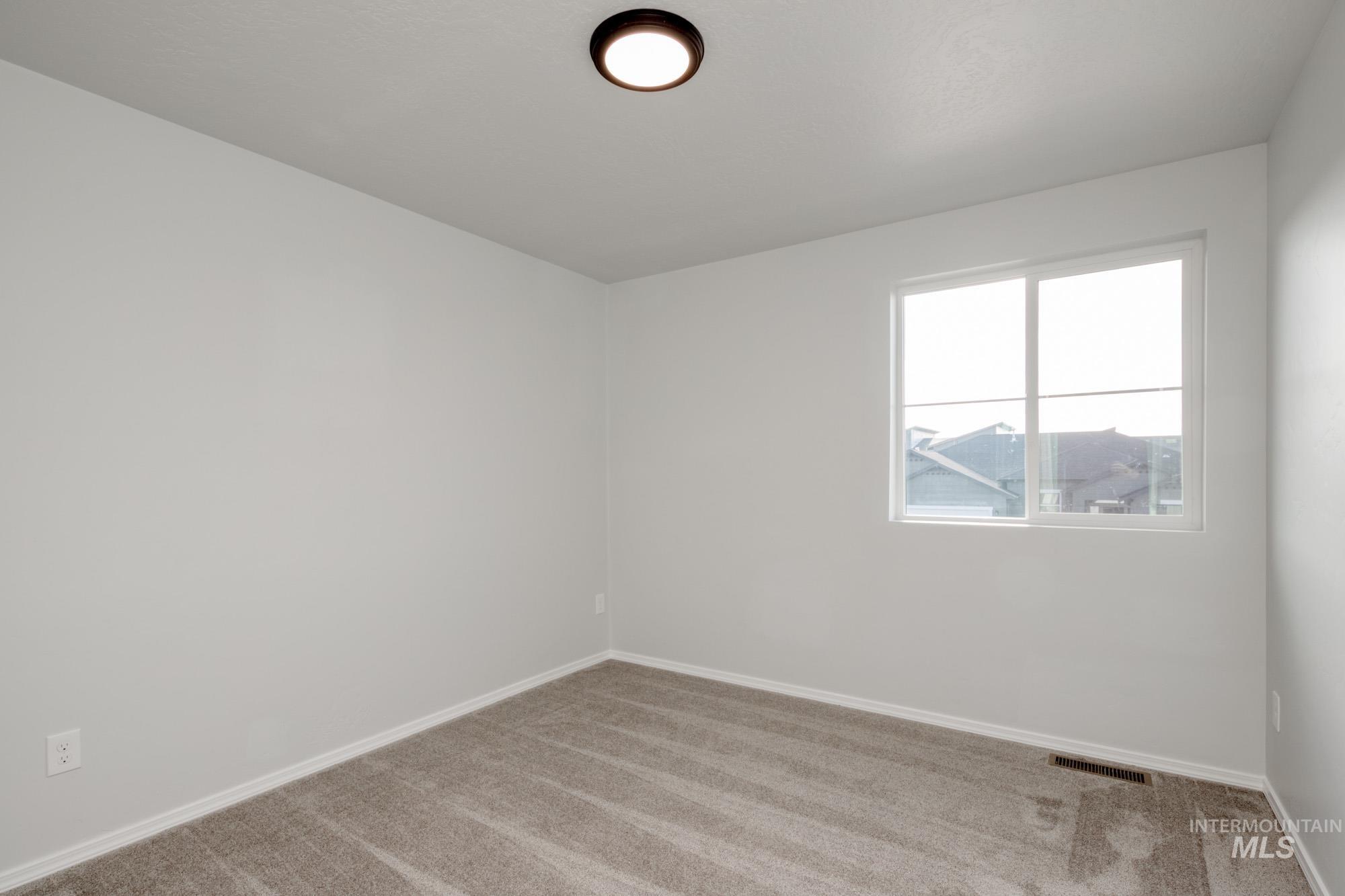 Carpeted spare room with baseboards