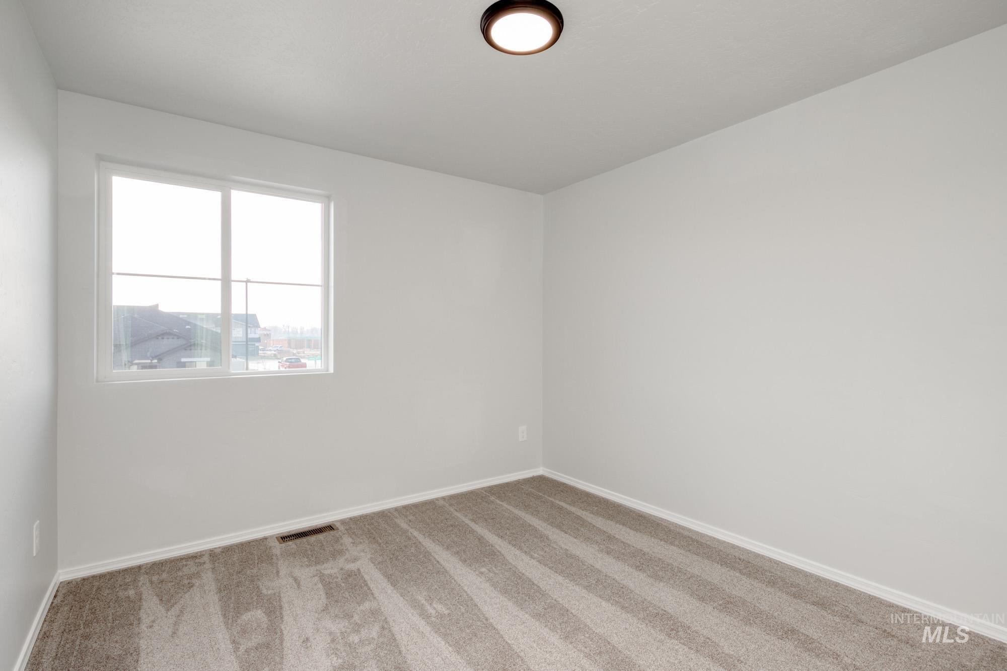 Spare room featuring carpet floors and baseboards
