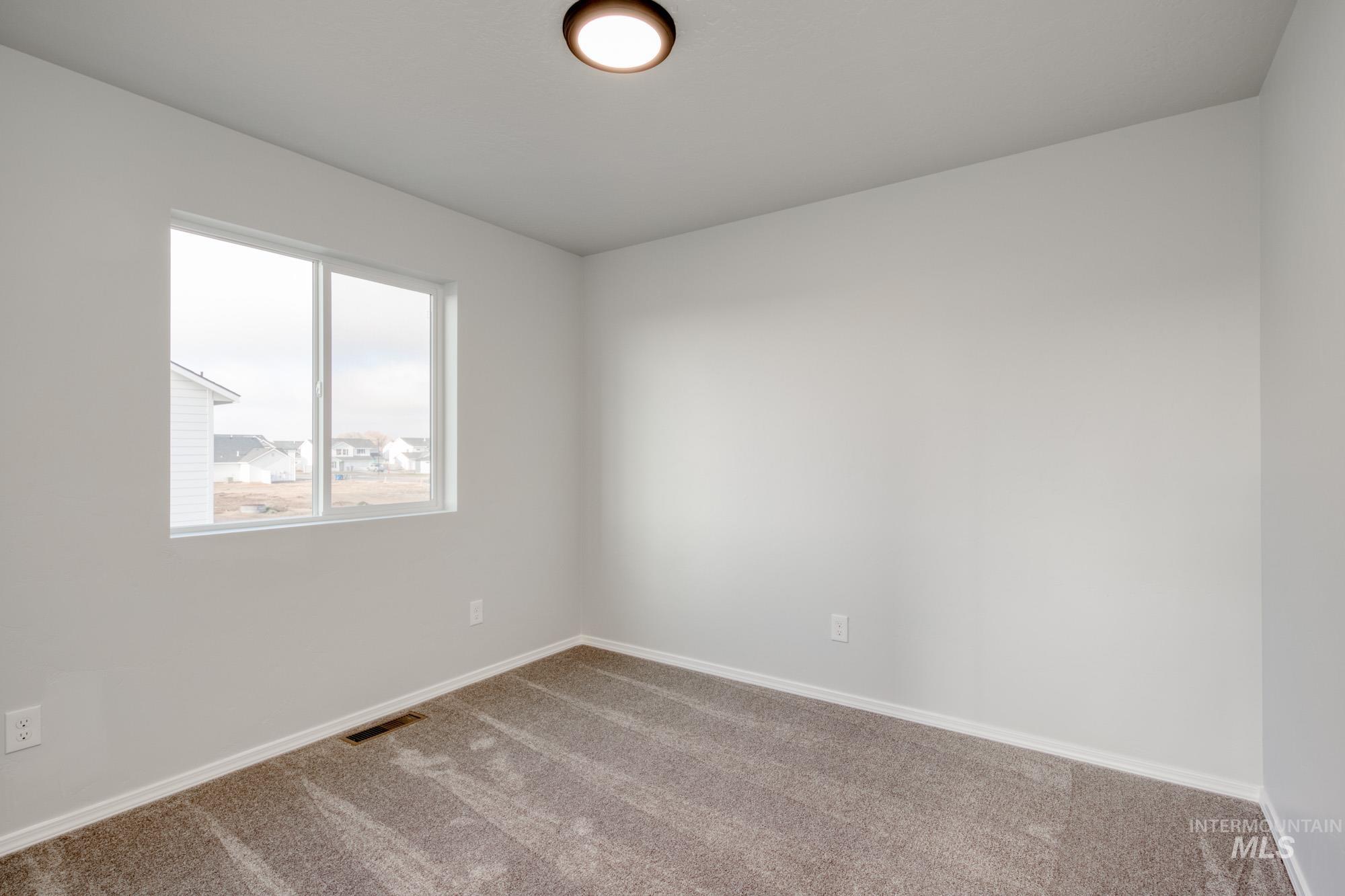 Carpeted spare room with baseboards