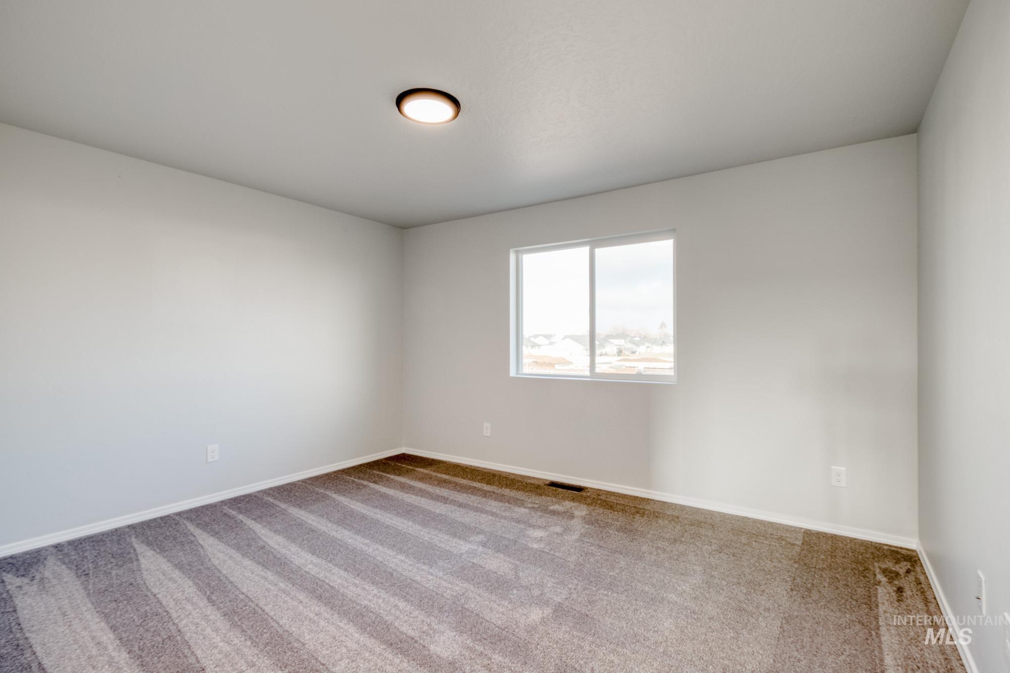 Spare room featuring carpet floors and baseboards