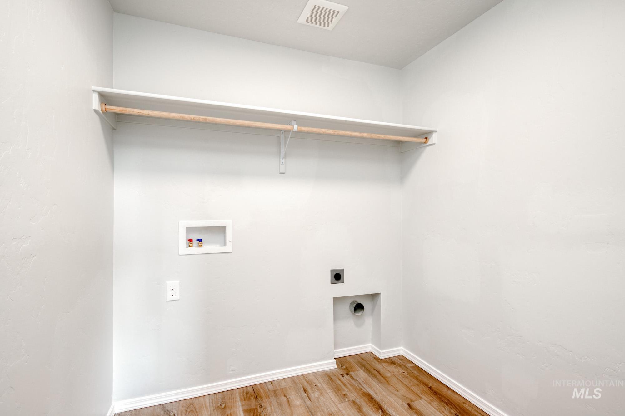 Washroom with light wood-style floors, washer hookup, and electric dryer hookup