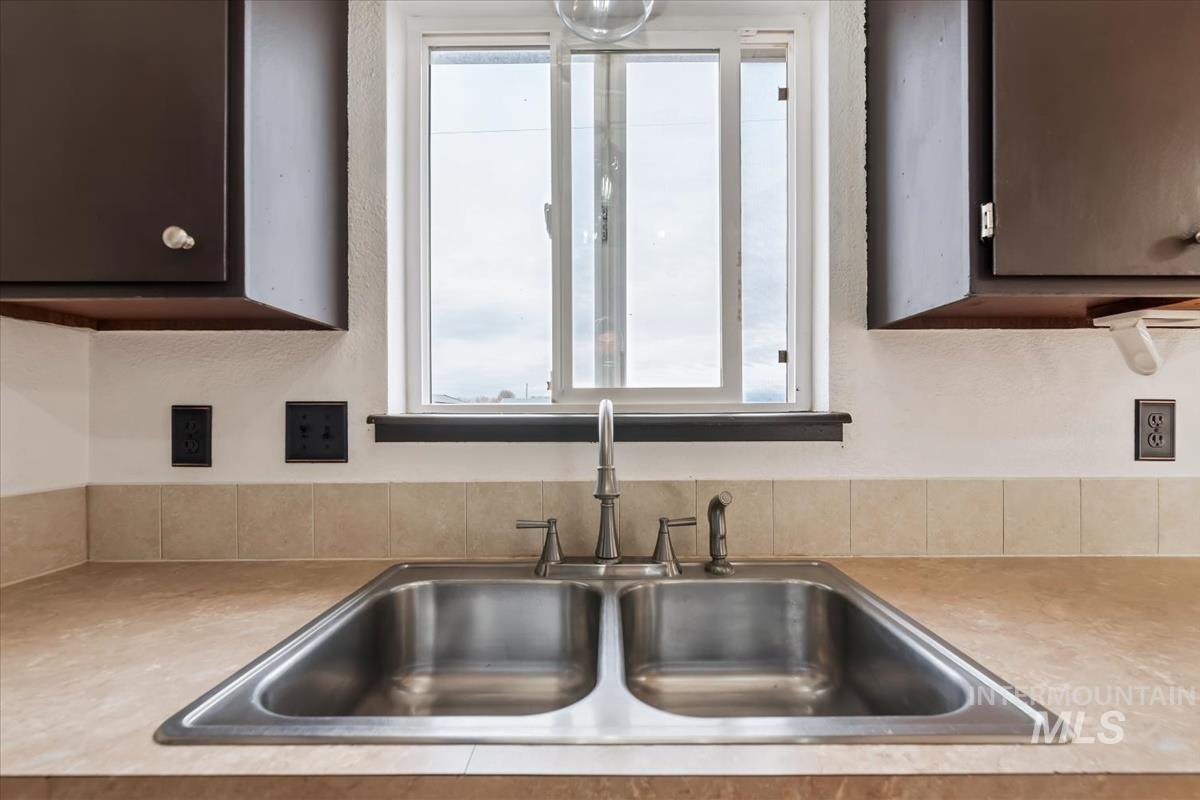 Kitchen with light countertops and dark brown cabinetry