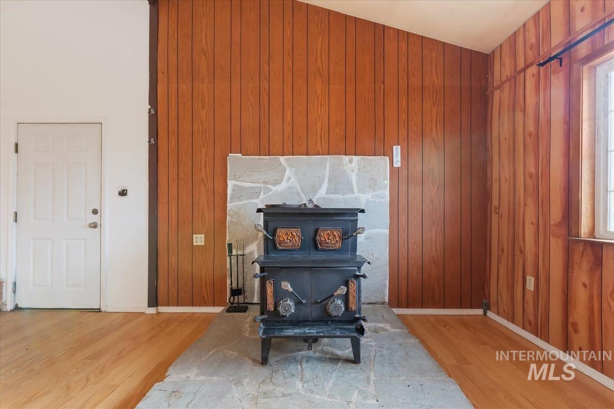 Detailed view of a wood stove, wooden walls, and wood finished floors