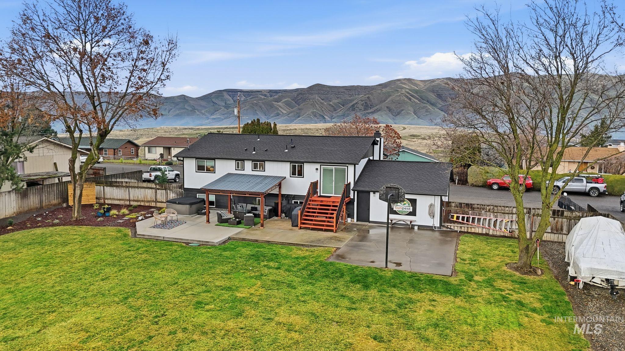 Back of house with a fenced backyard, a patio, a mountain view, and a chimney