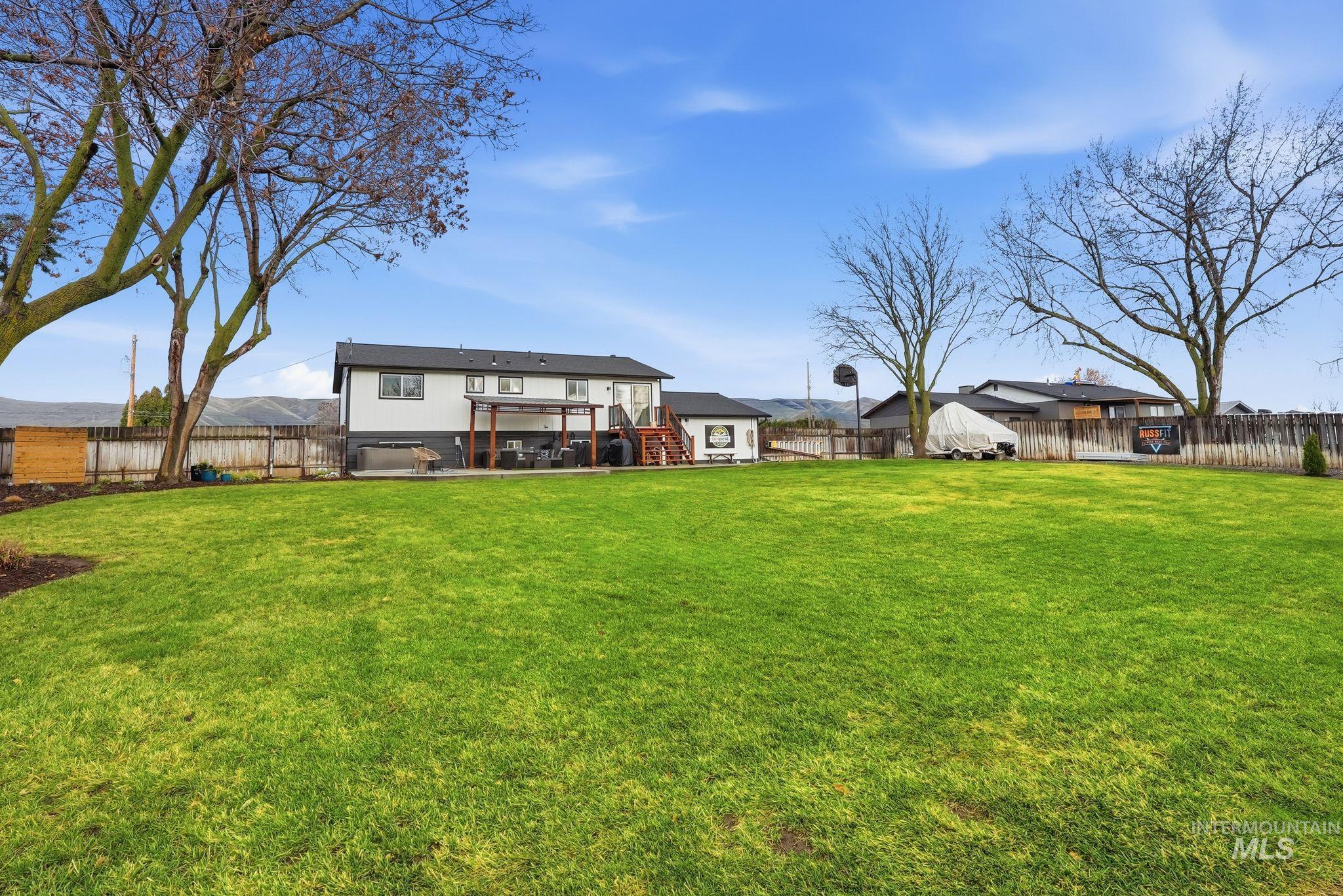 Back of house featuring a fenced backyard, stairway, and a patio
