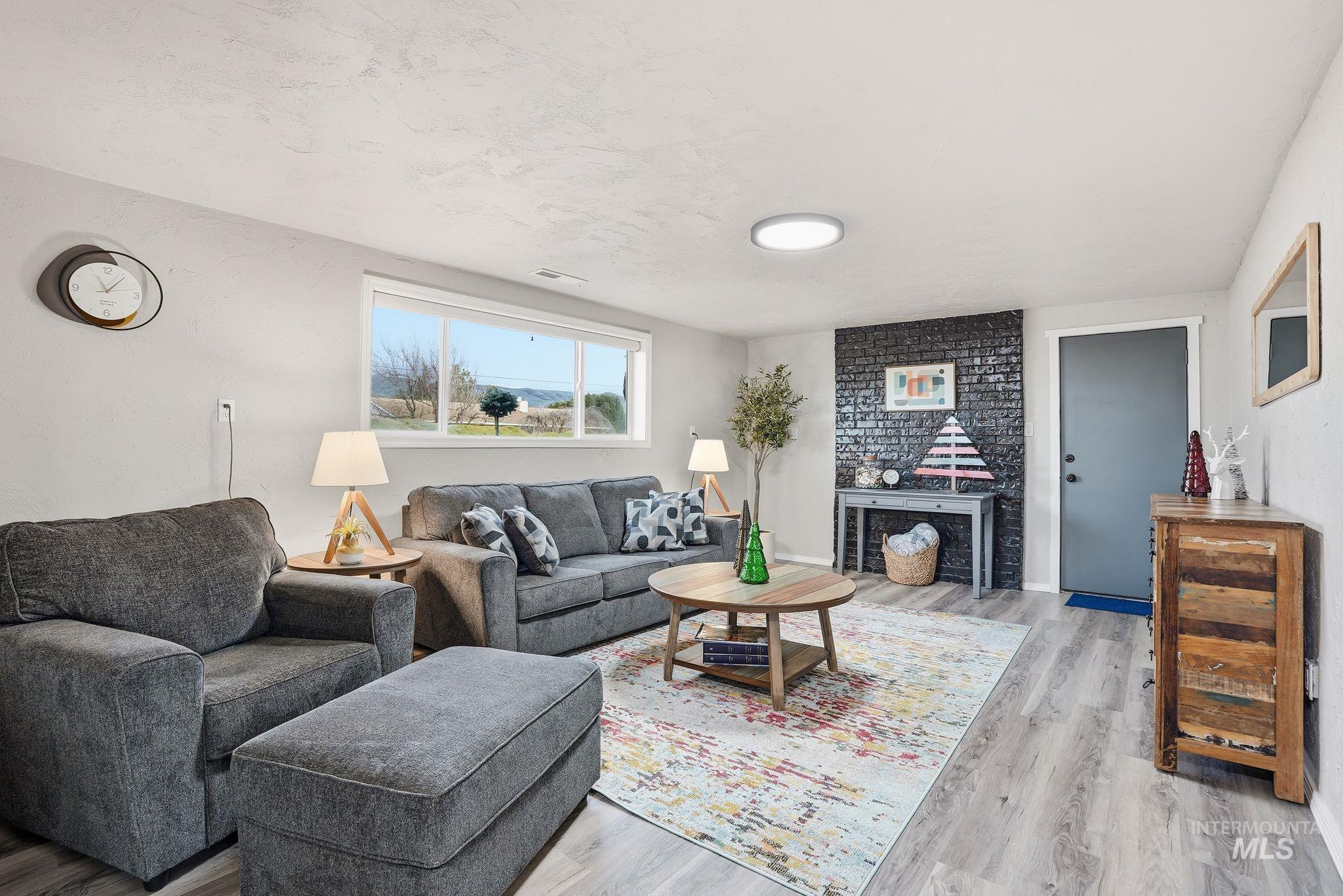 Living area featuring light wood finished floors and a textured ceiling