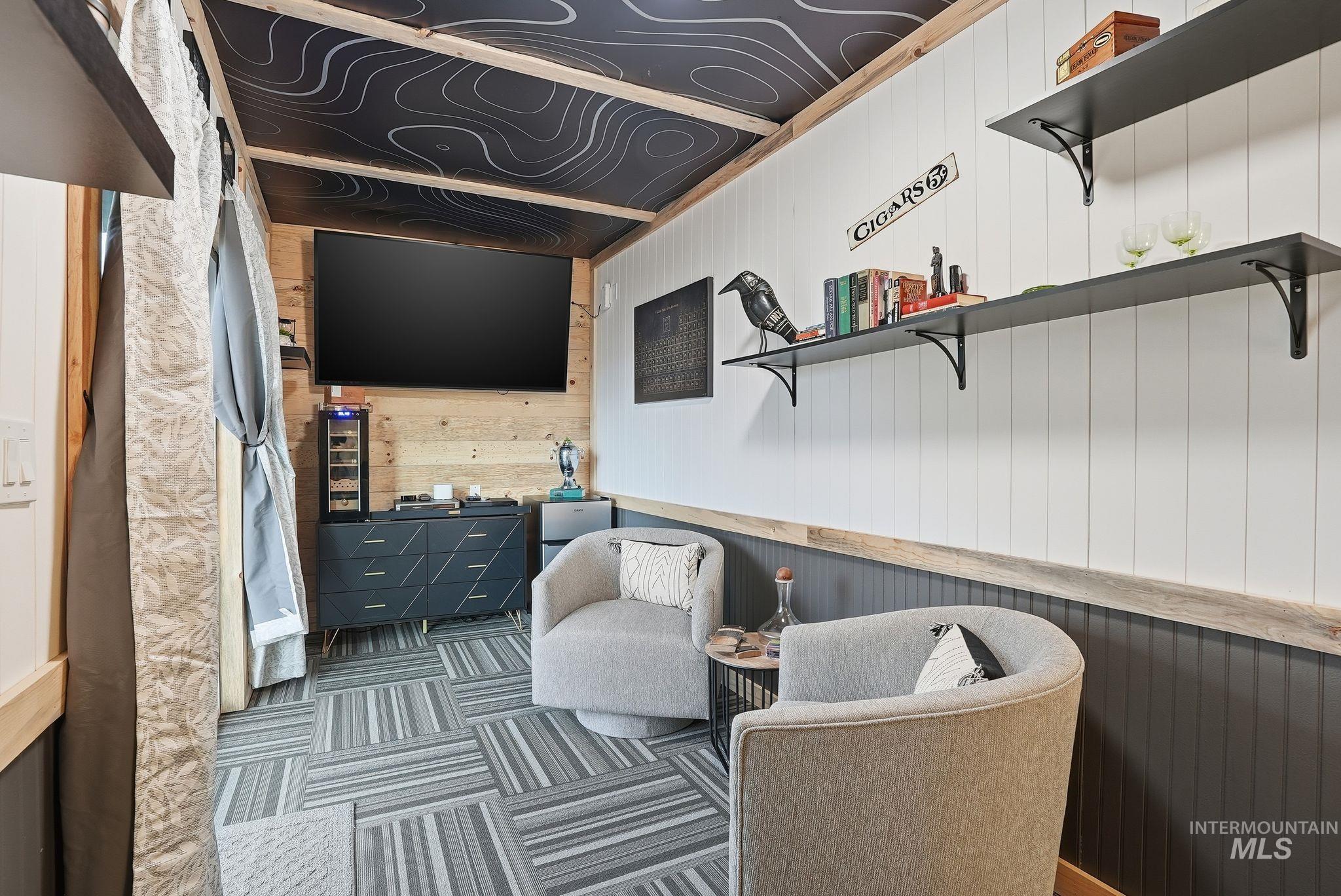 Living area with wooden walls and carpet flooring