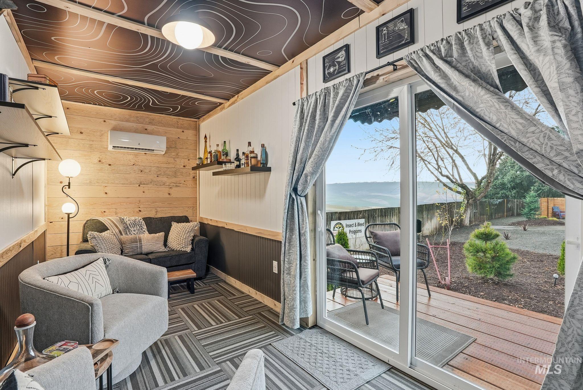 Interior space featuring wooden walls, a water view, and a wall mounted AC