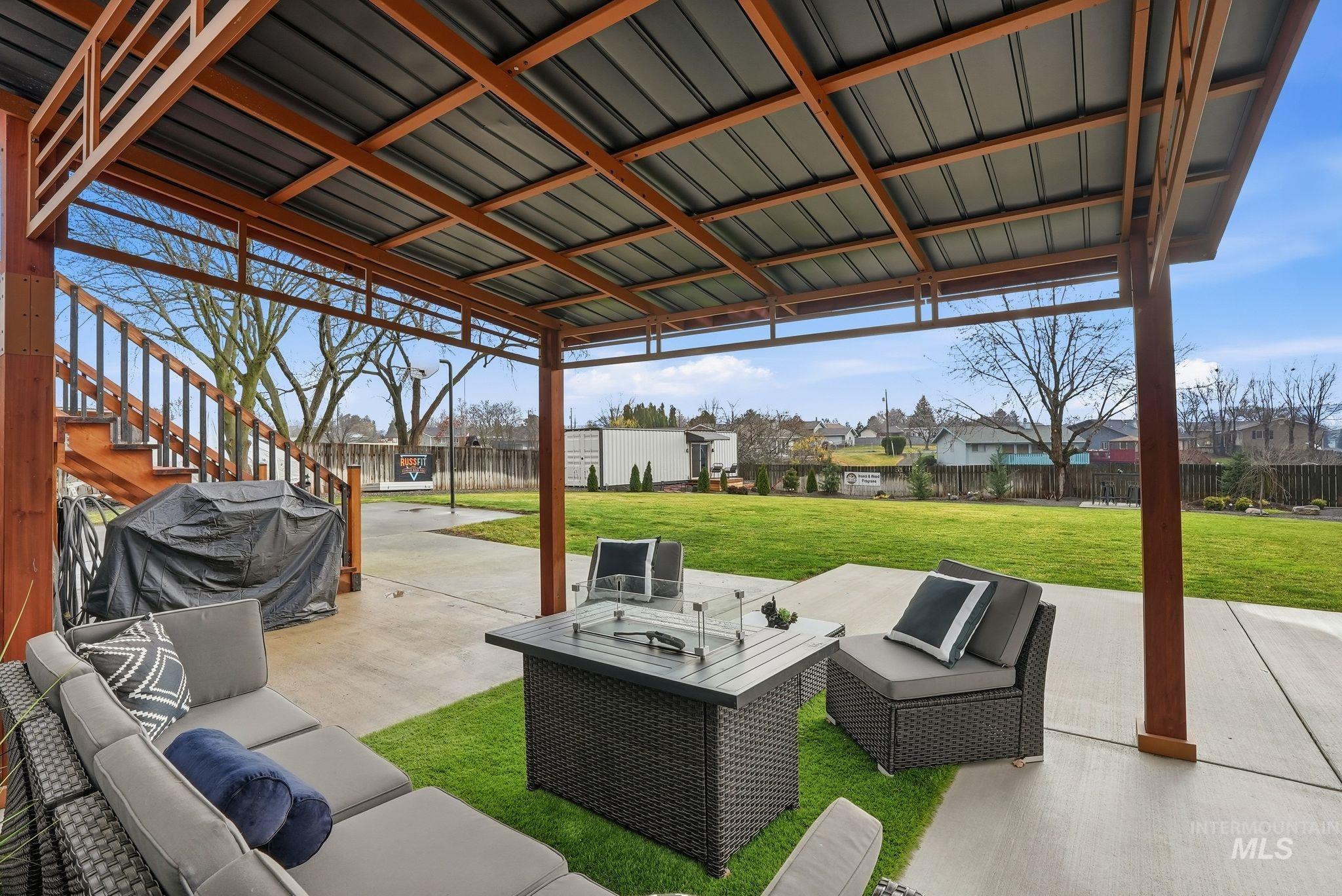 Fenced backyard featuring an outdoor living space, a grill, stairs, and a patio area