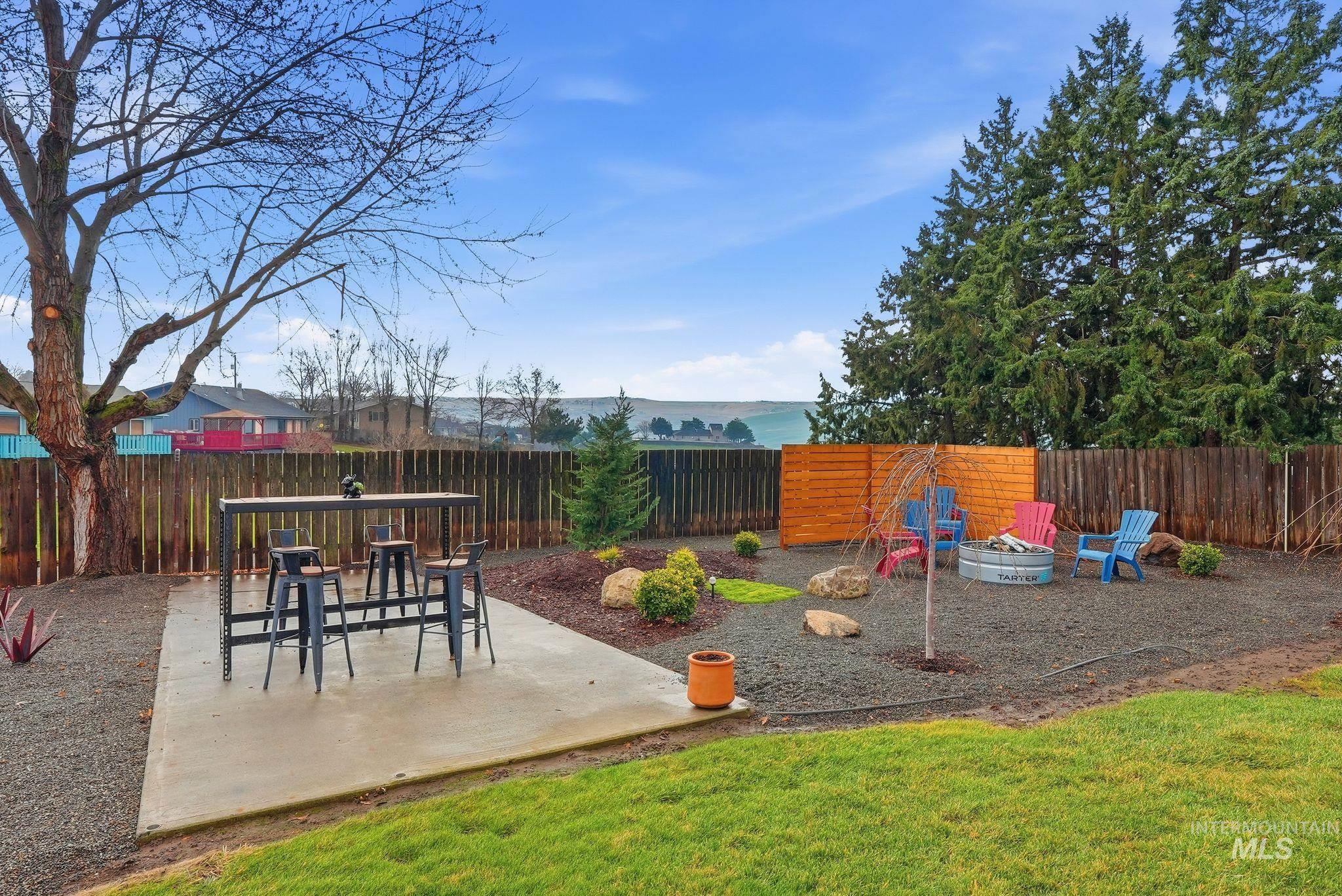 Fenced backyard with a patio and an outdoor fire pit
