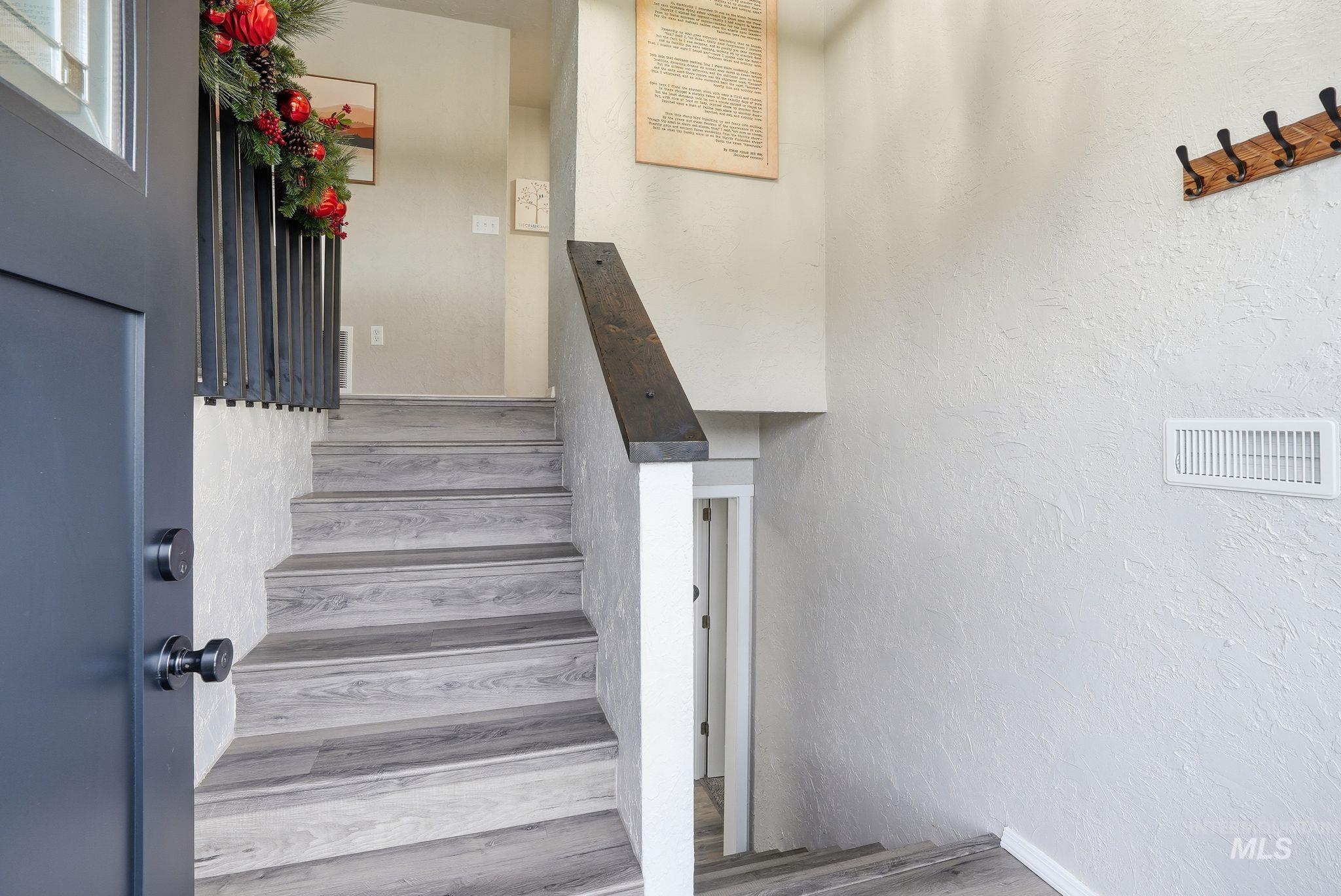 Staircase featuring a textured wall and baseboards