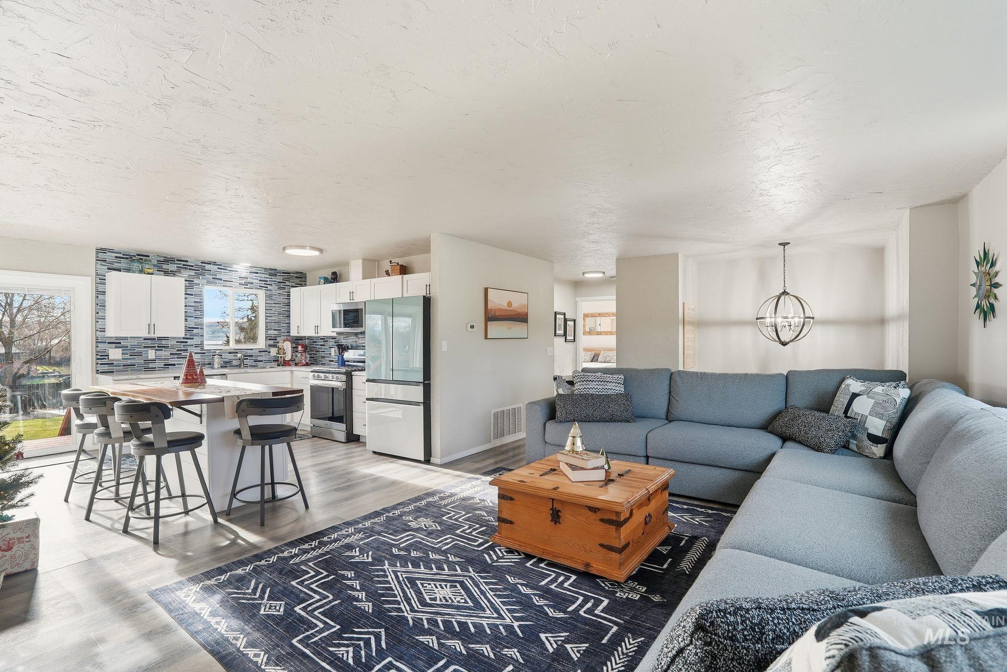 Living room with light wood-style flooring and a textured ceiling