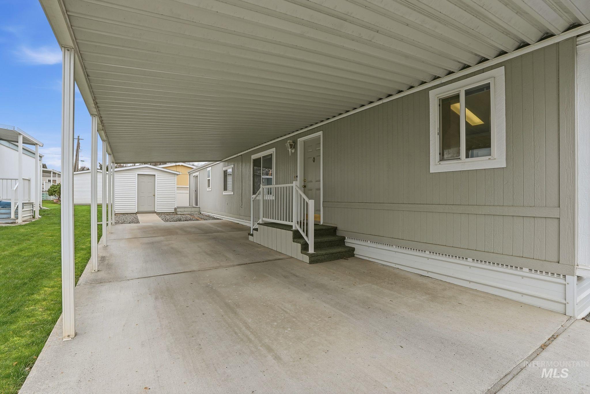 View of patio featuring an attached carport and a storage unit