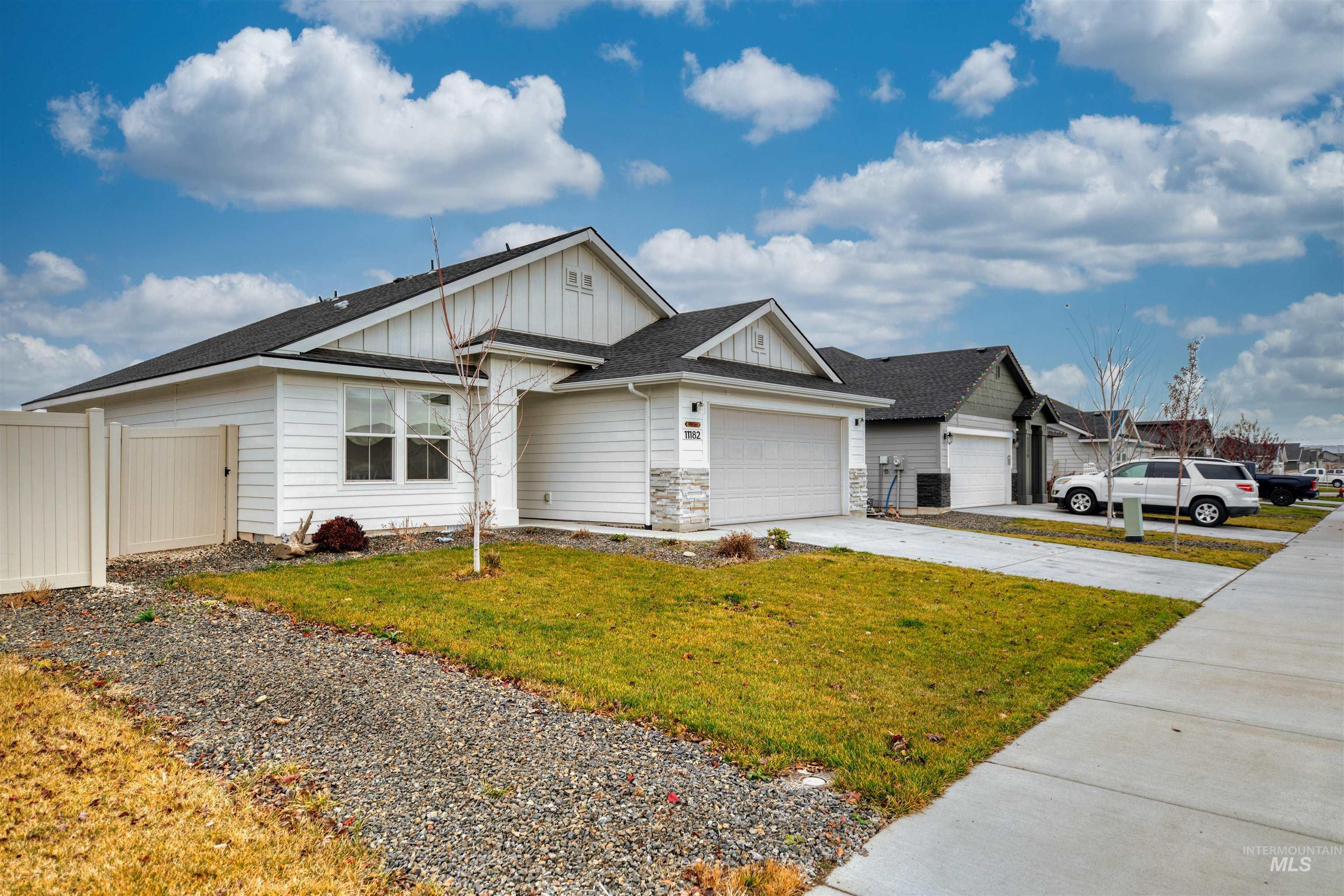 View of front facade with board and batten siding, roof with shingles, concrete driveway, and an attached garage