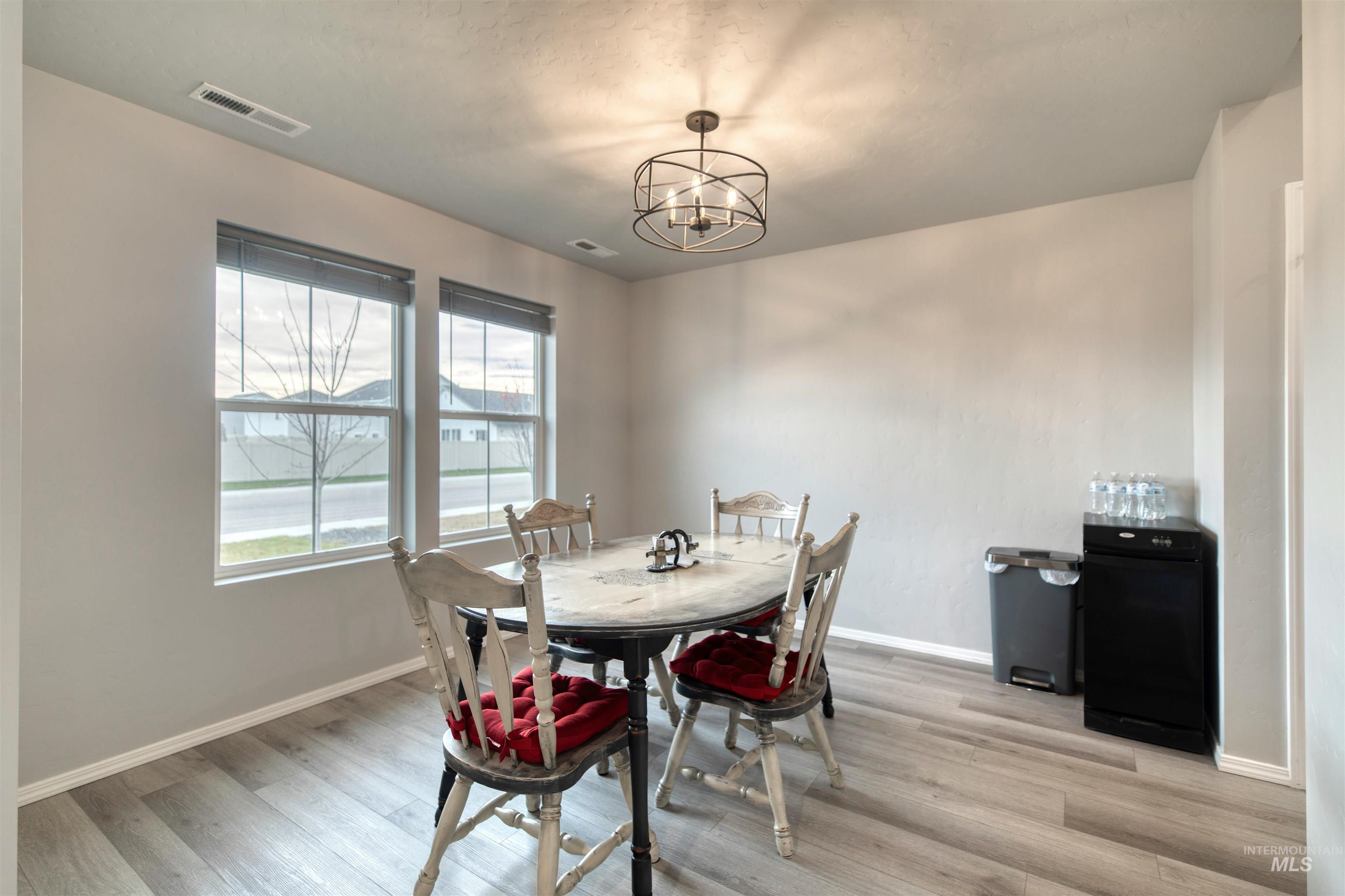 Dining space with light wood-type flooring and a chandelier