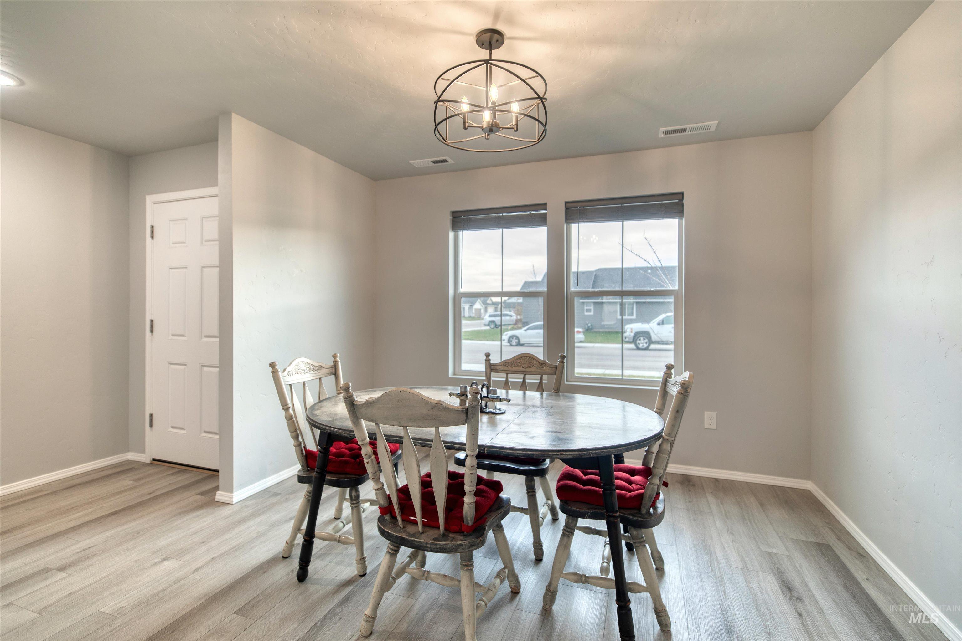 Dining area with a chandelier and light wood-type flooring