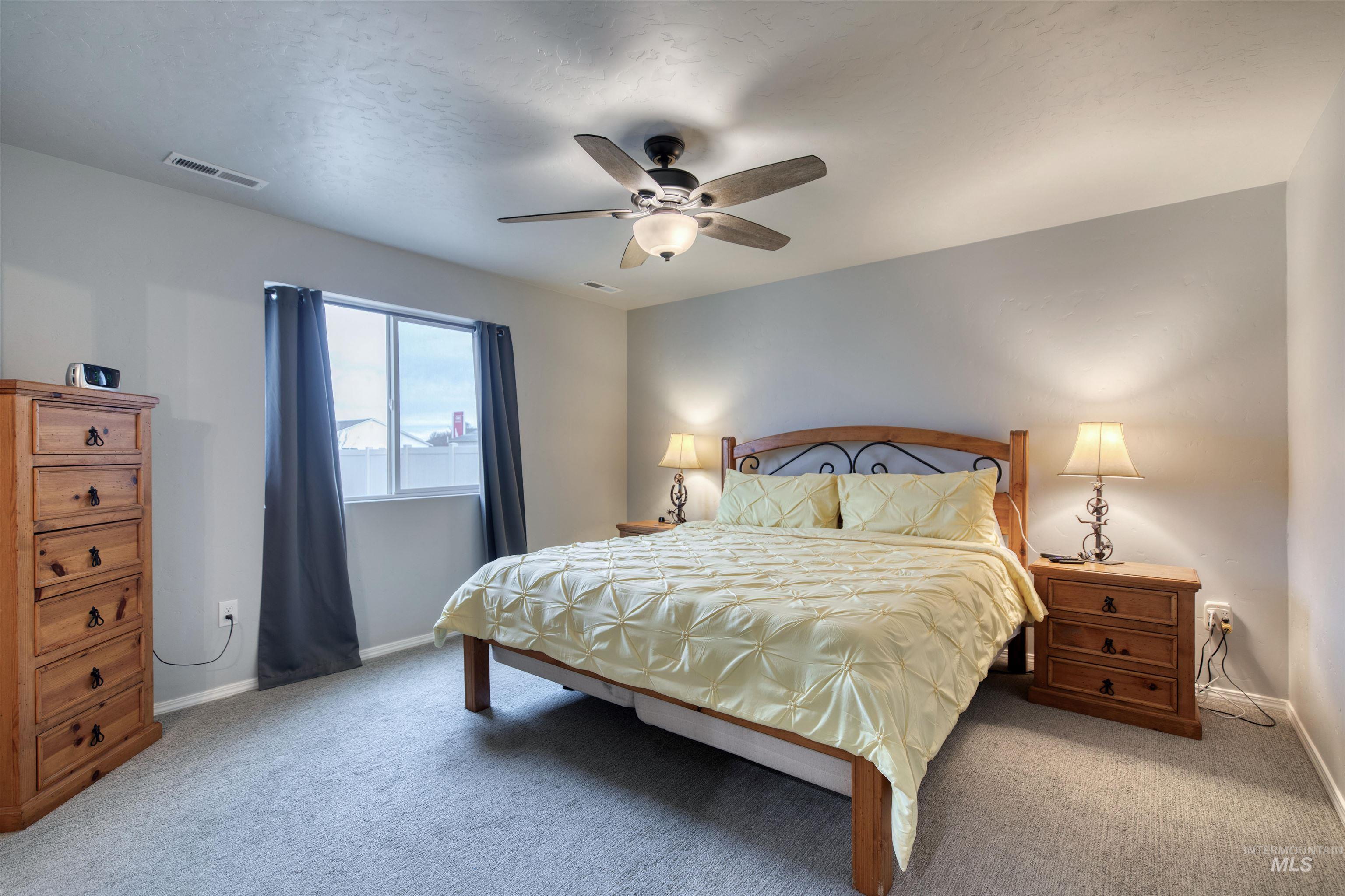 Bedroom with light carpet and ceiling fan