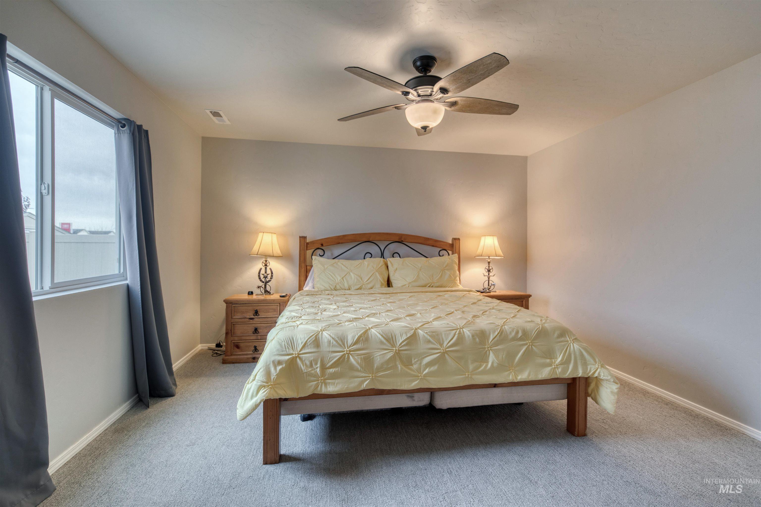 Bedroom featuring light carpet and a ceiling fan