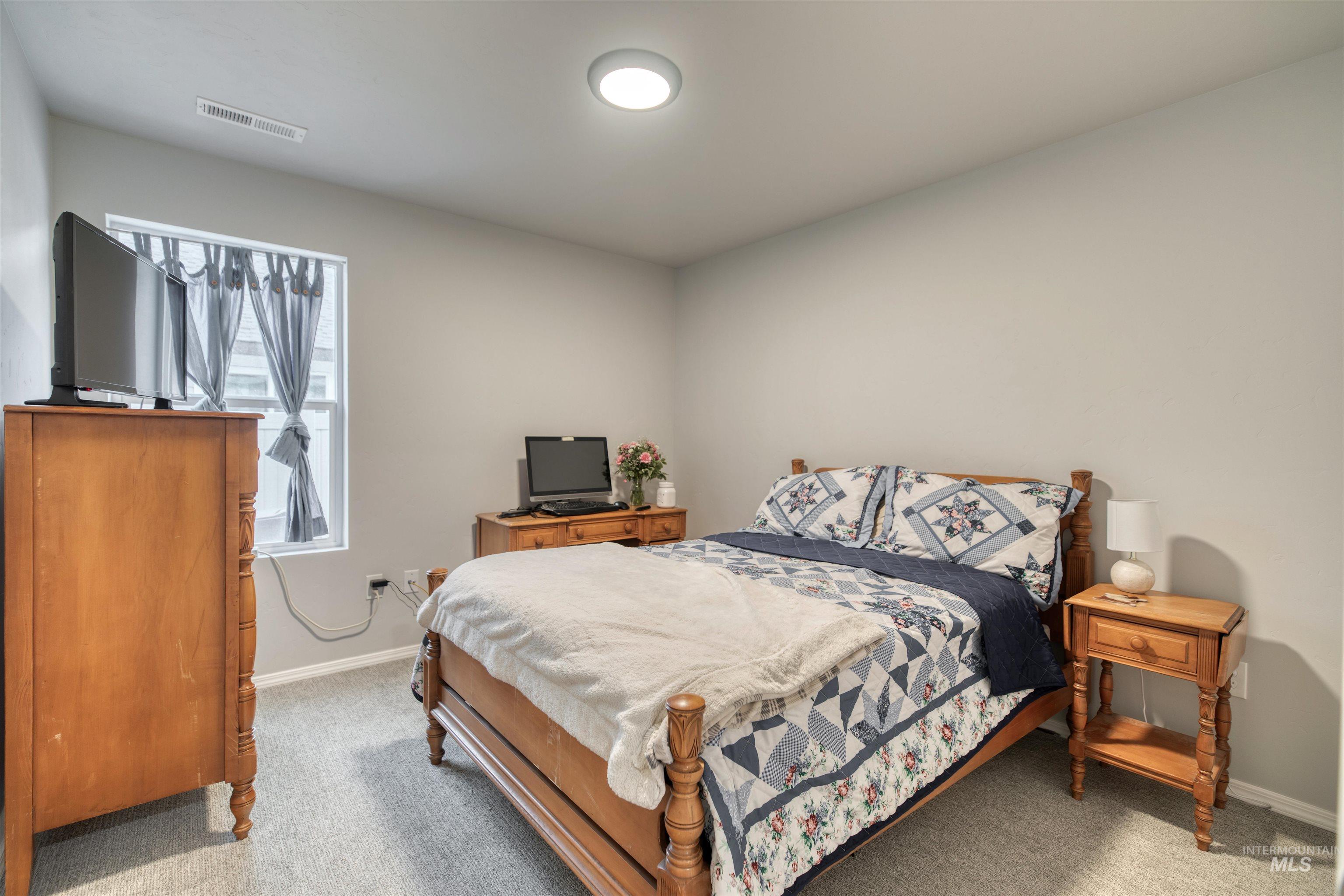 Bedroom with light colored carpet and baseboards