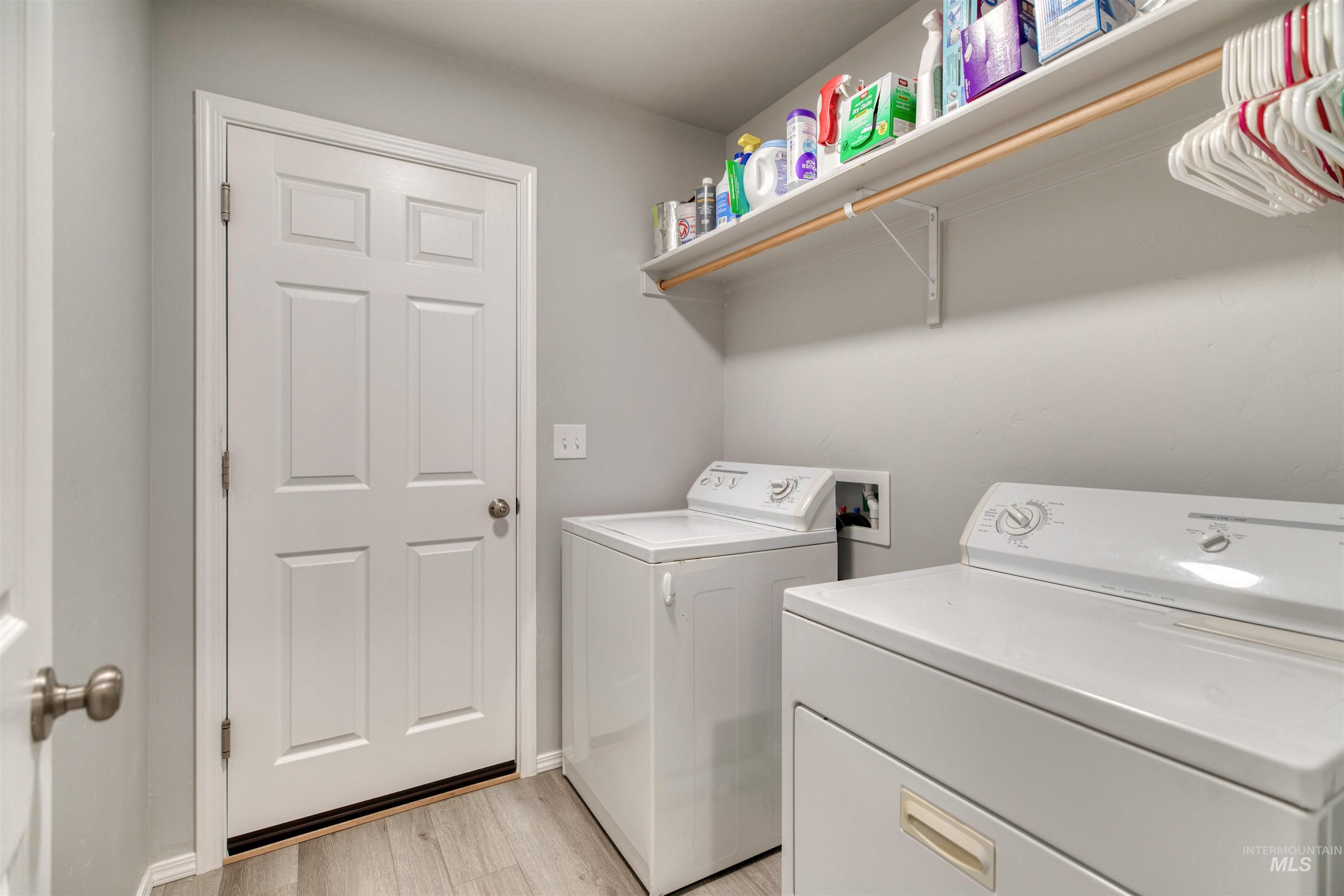 Washroom featuring light wood-style flooring and washer and dryer