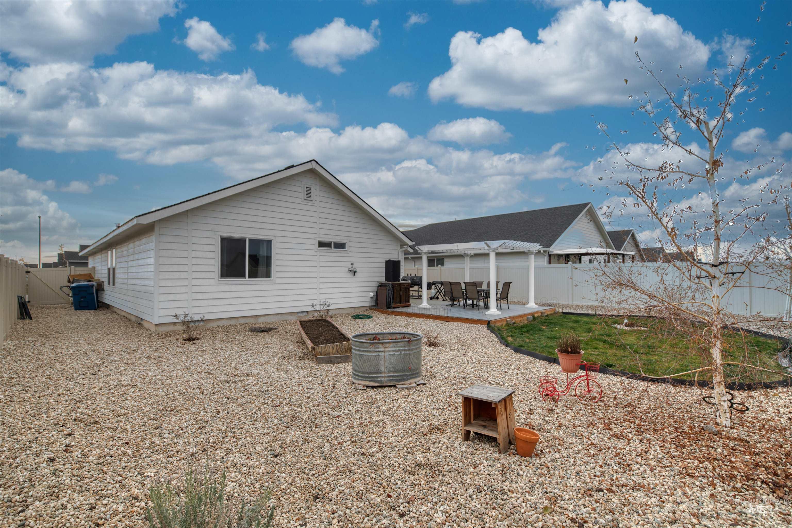 Back of property featuring a patio area, a fenced backyard, and a fire pit