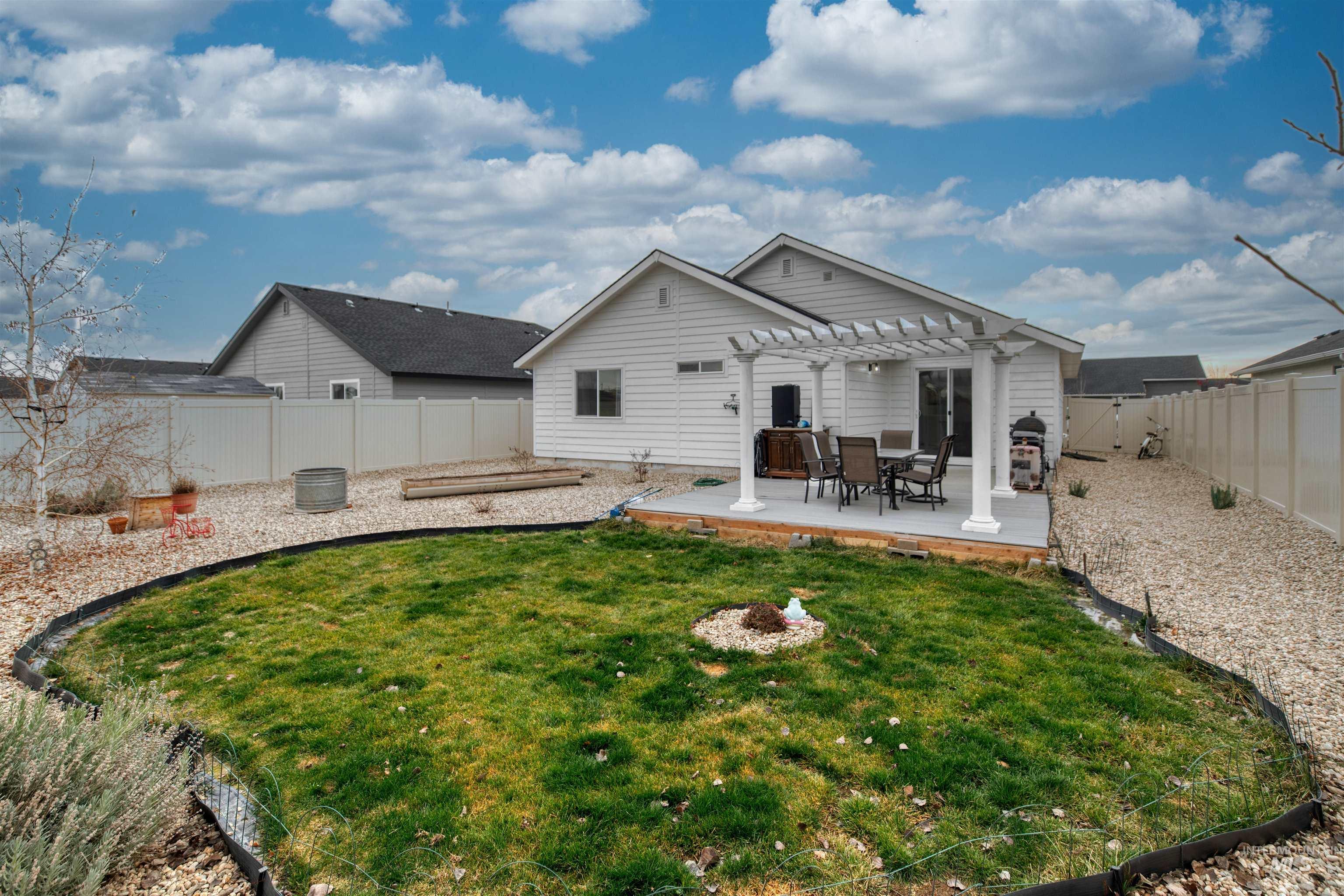 Rear view of property featuring a fenced backyard, a deck, and a pergola