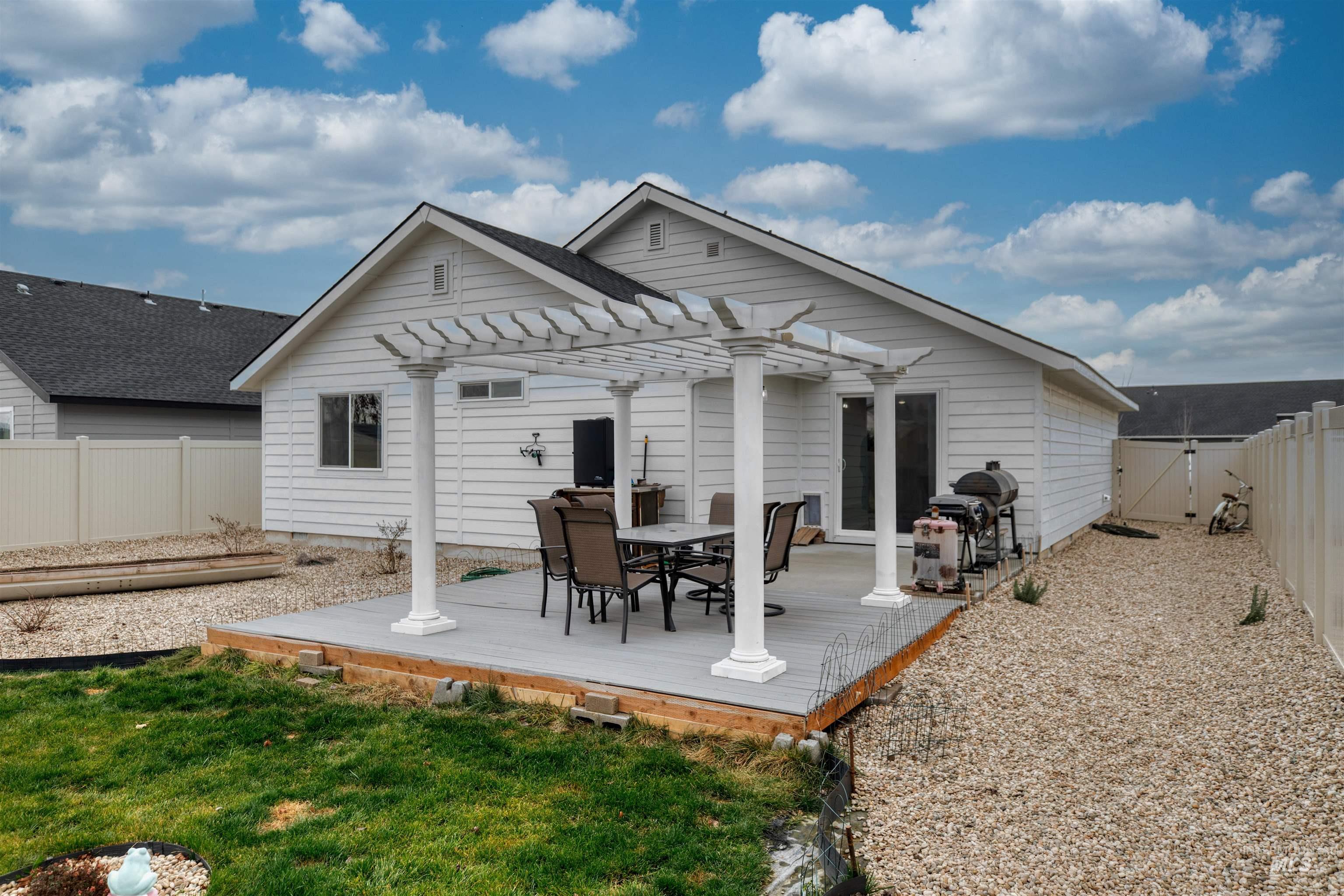 Back of house with a fenced backyard and a wooden deck