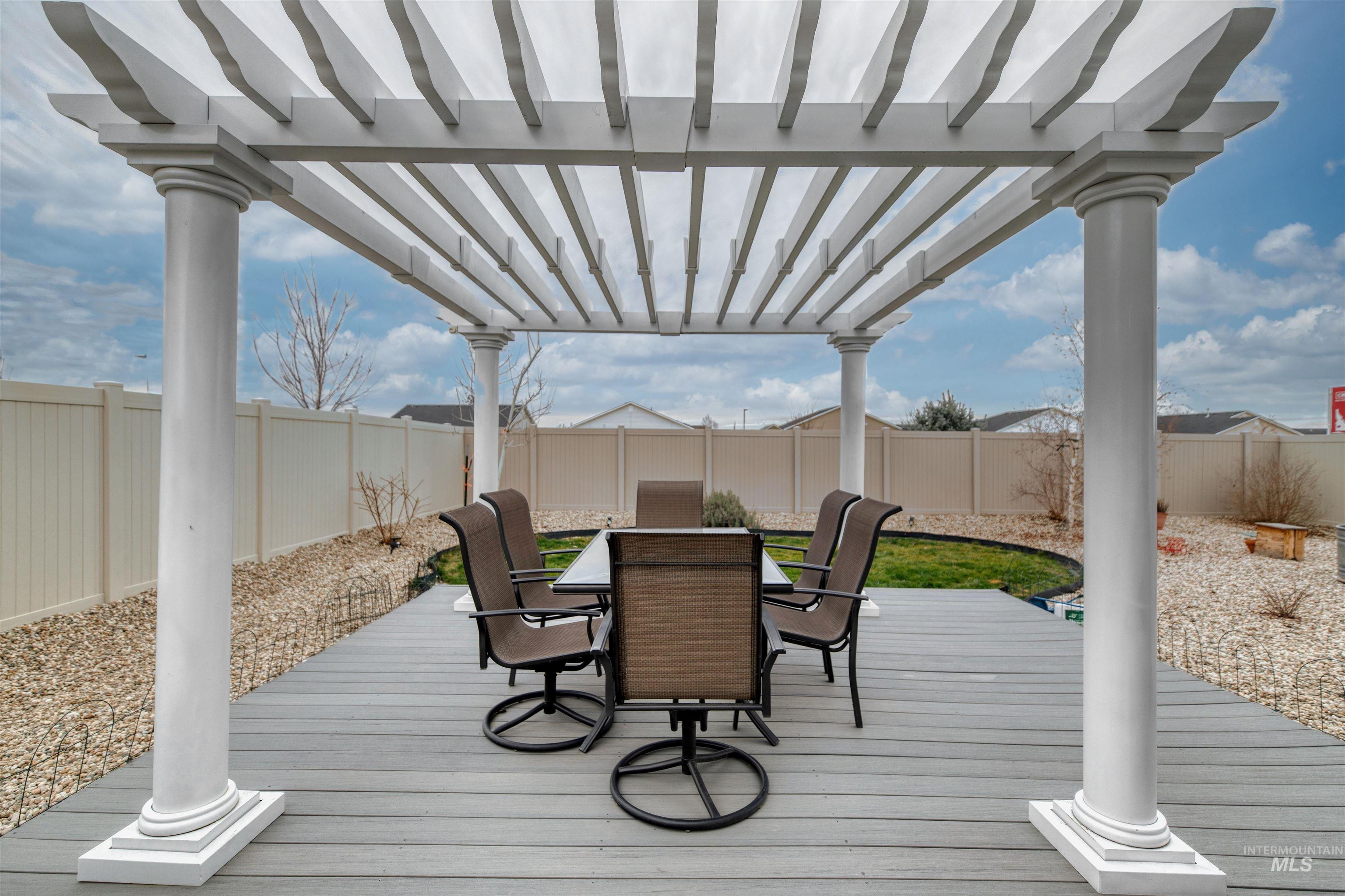 Wooden deck featuring outdoor dining area, a fenced backyard, and a pergola