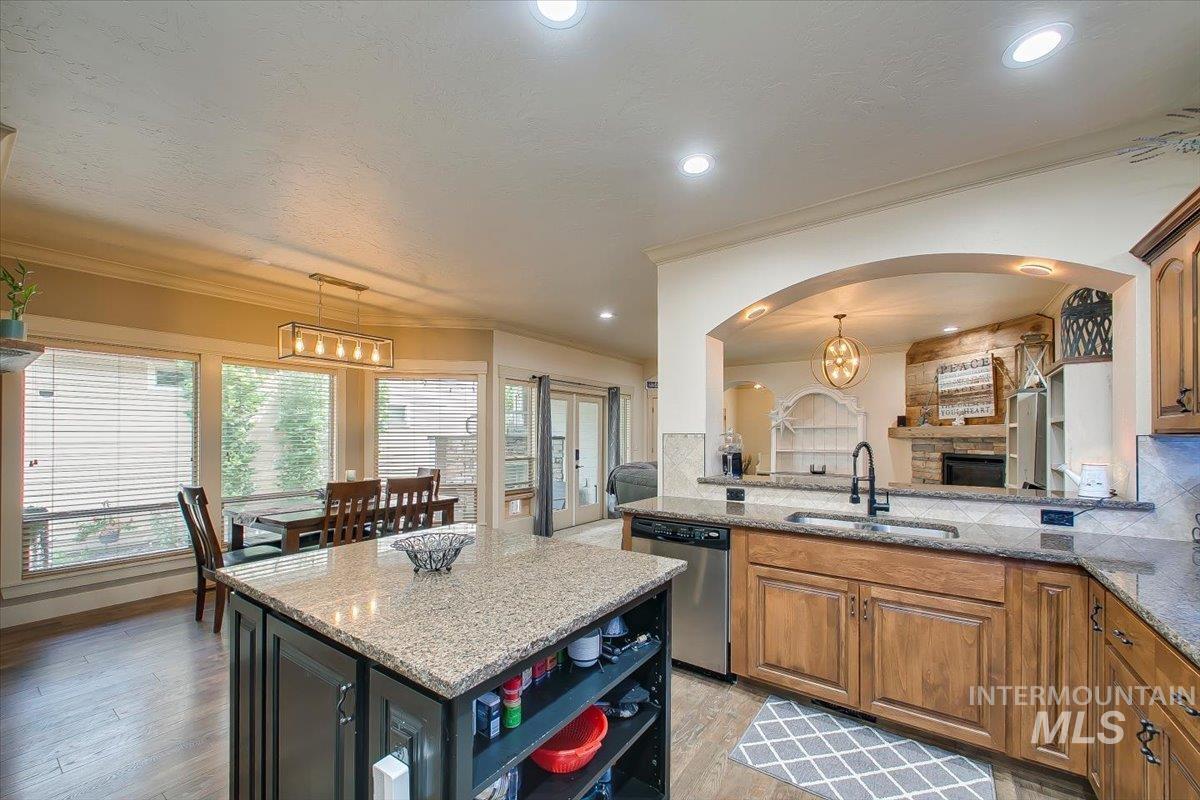 Kitchen featuring pendant lighting, open shelves, light stone countertops, tasteful backsplash, and a chandelier