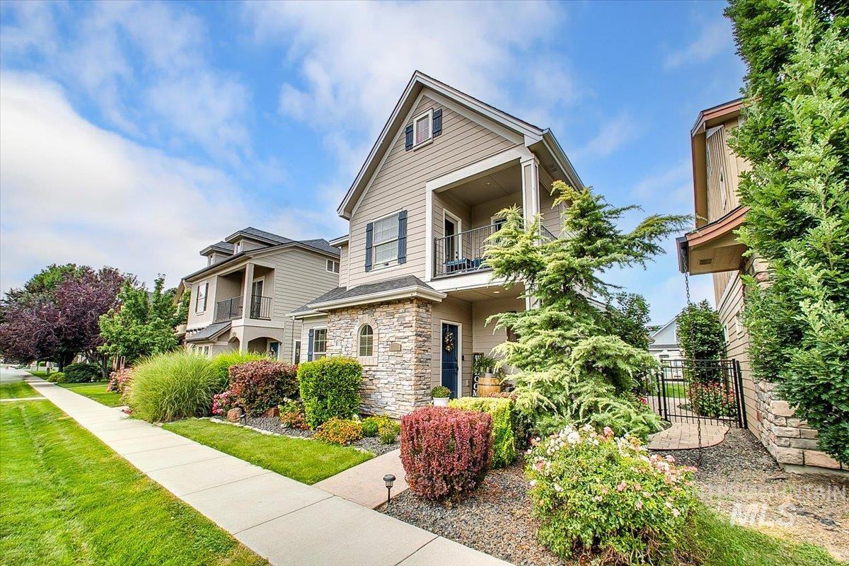 View of front of house with a balcony and stone siding