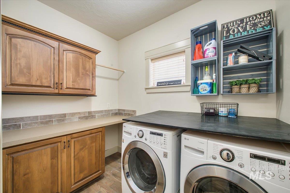 Laundry area featuring washing machine and clothes dryer, light wood-type flooring, and cabinet space