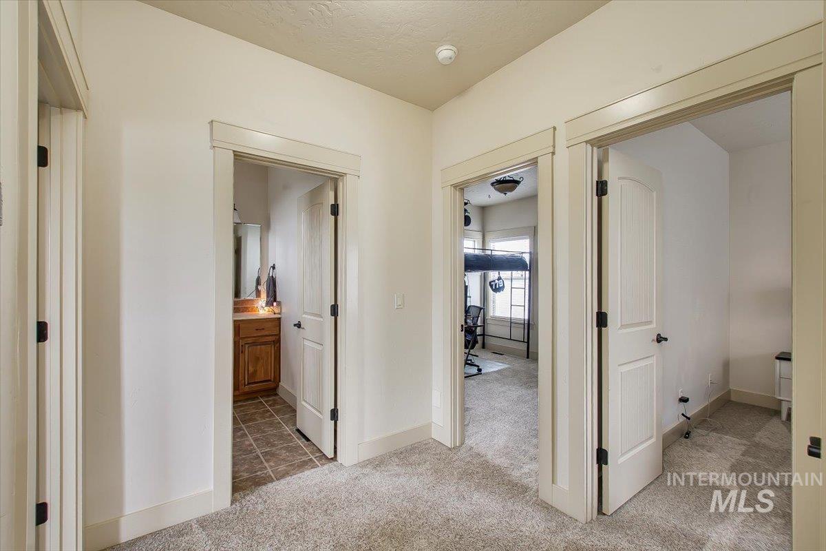 Hall featuring light carpet and a textured ceiling