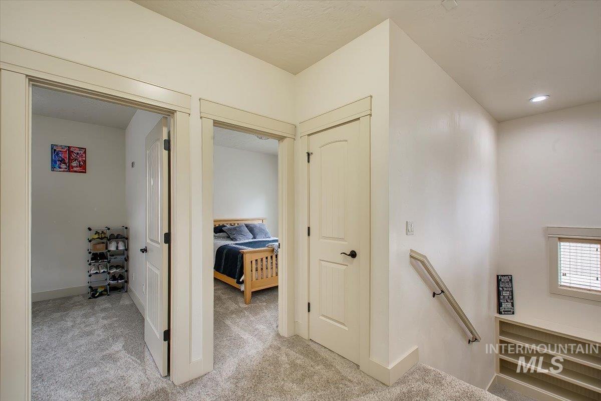 Hallway featuring an upstairs landing and carpet floors