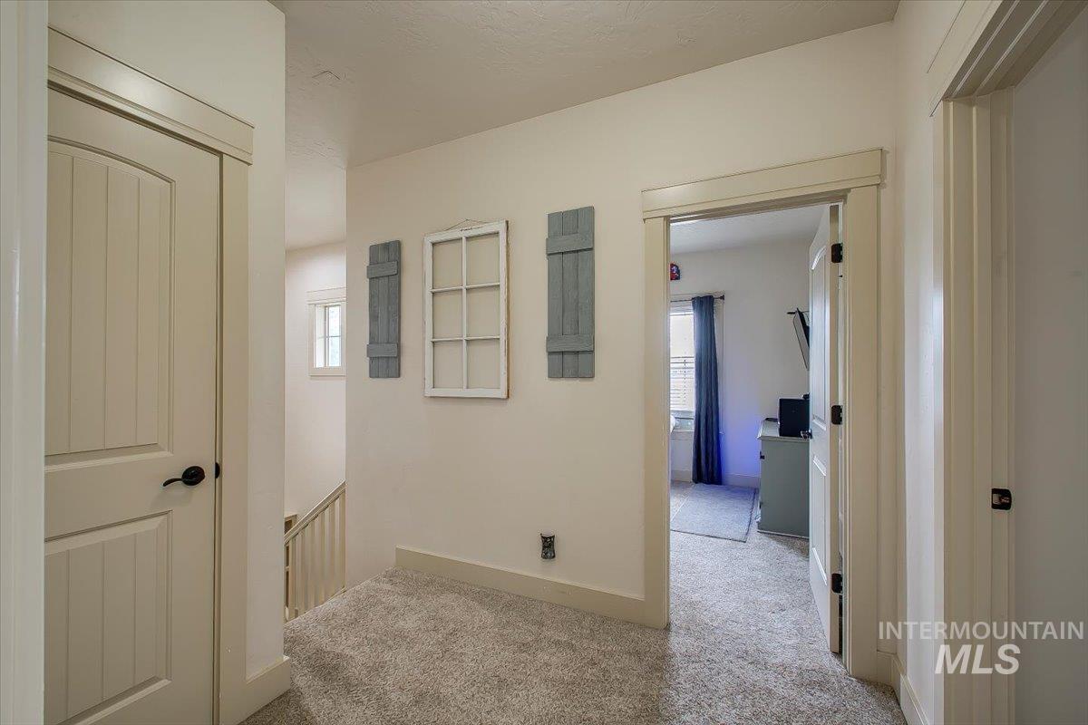 Hall featuring light carpet and an upstairs landing