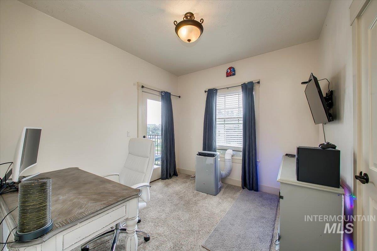 Home office with light colored carpet and baseboards
