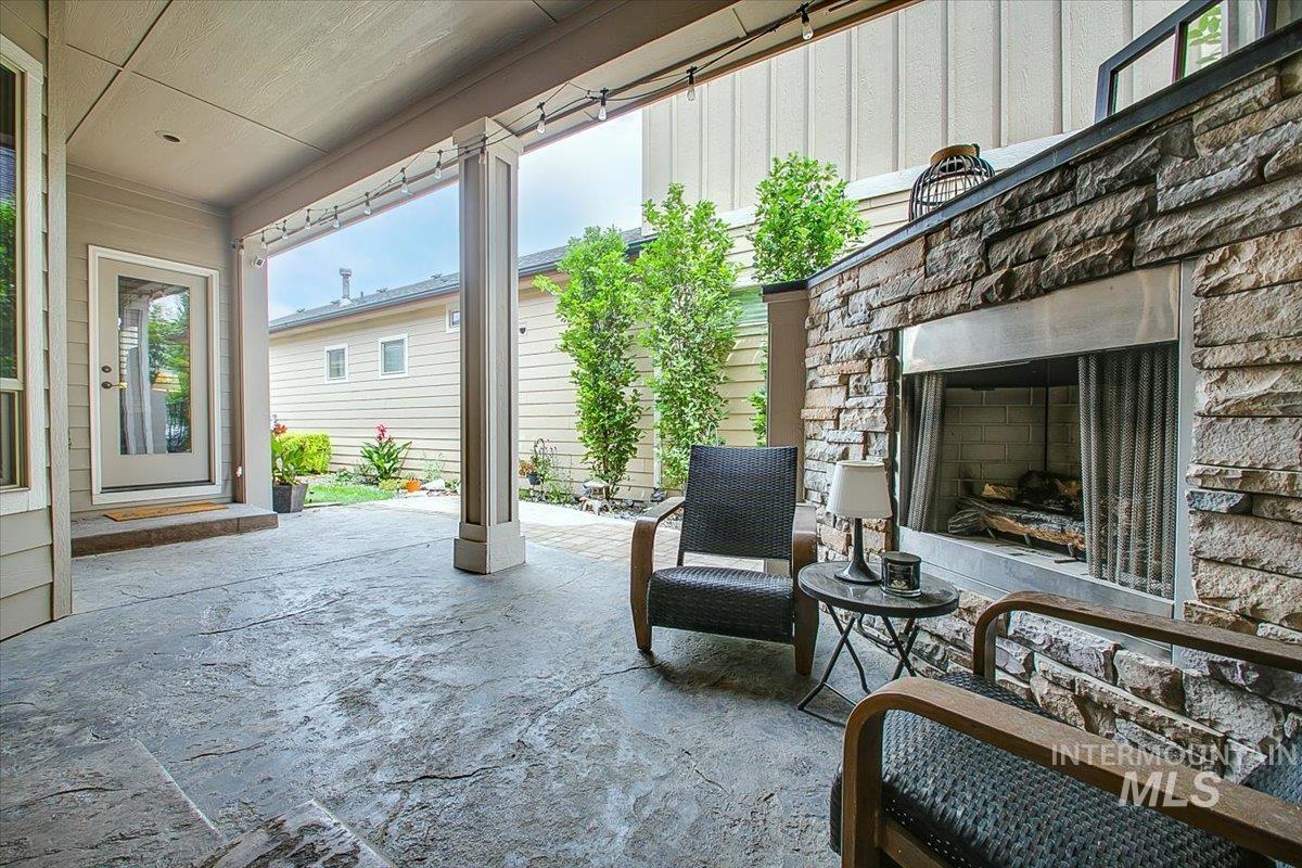 View of patio featuring an outdoor stone fireplace