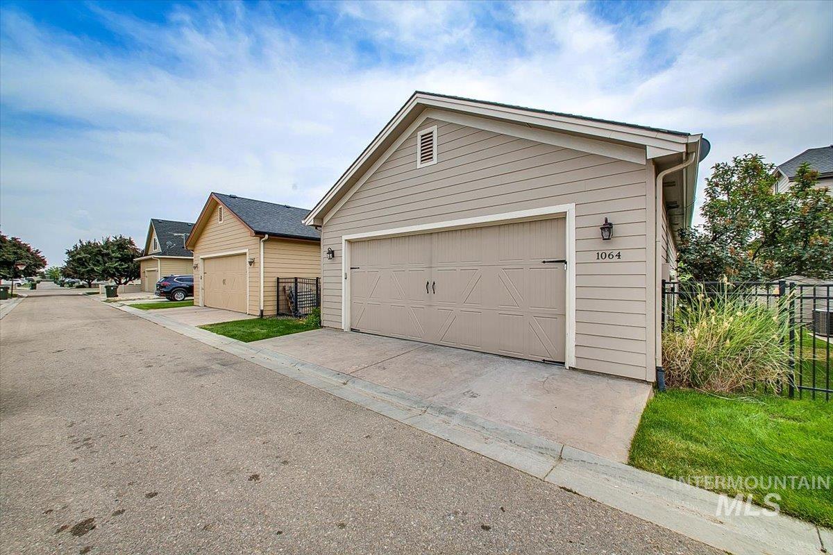 View of front of home featuring a garage and an outbuilding