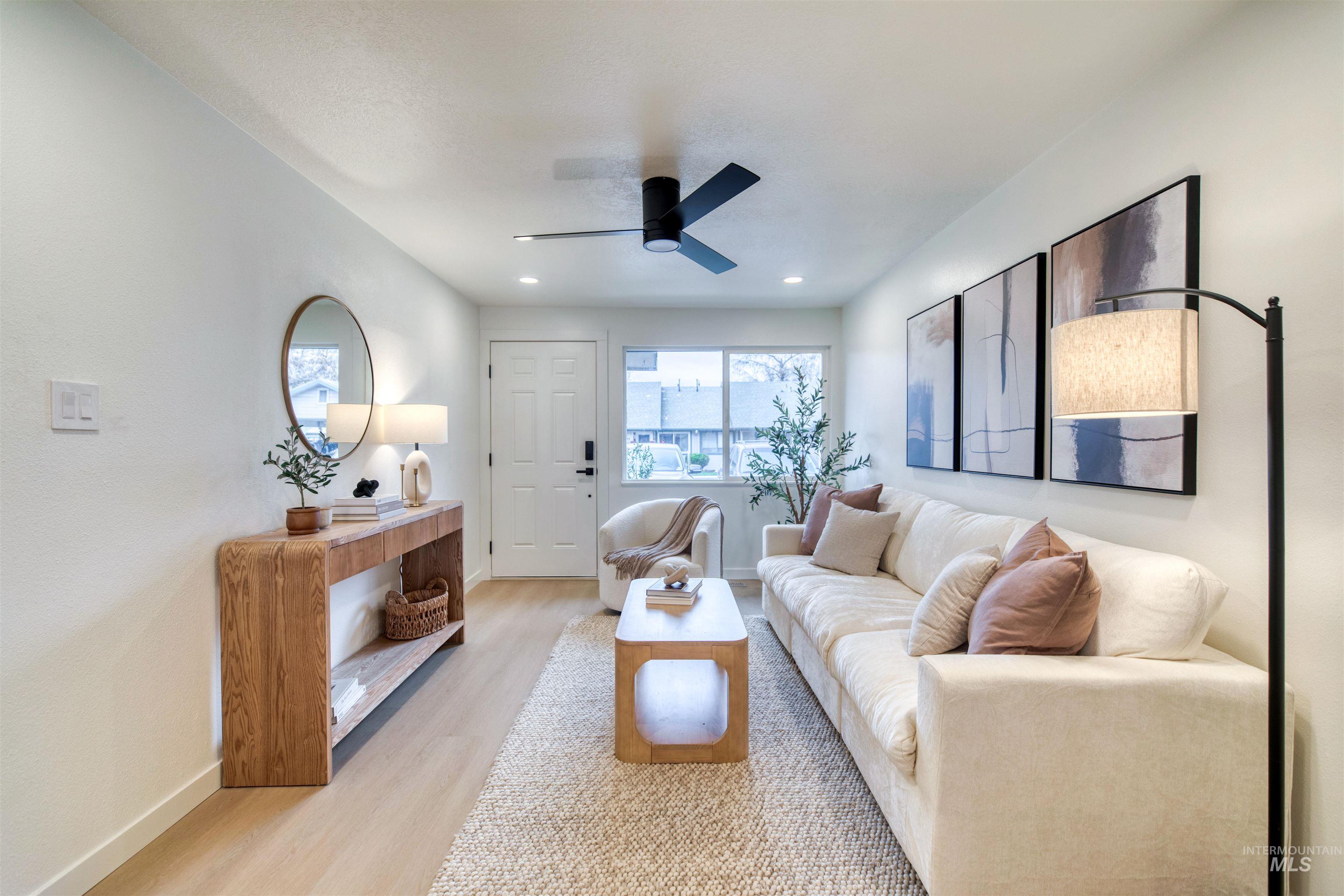 Living area with light wood finished floors and a ceiling fan