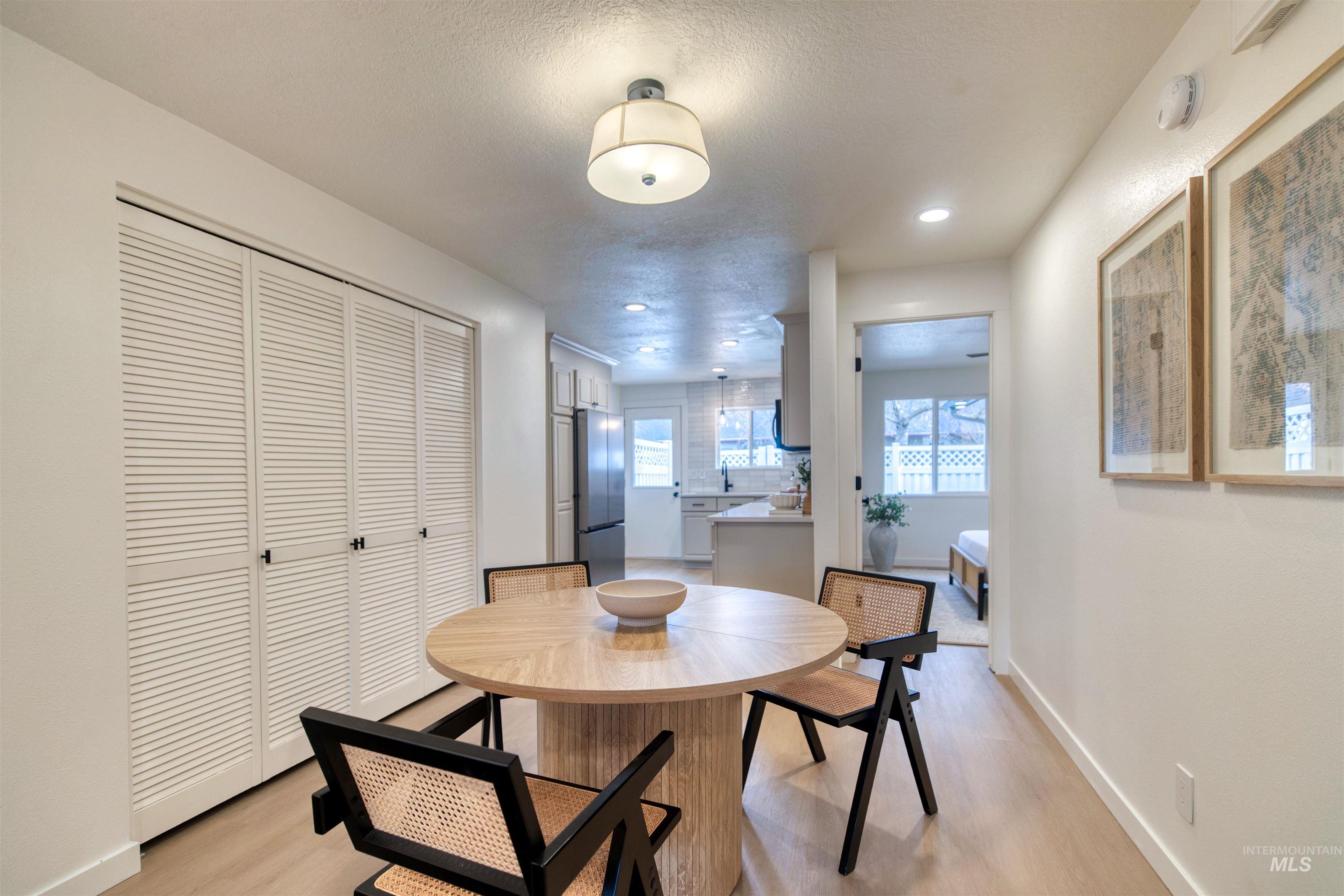 Dining area with light wood-type flooring, a textured ceiling, and recessed lighting