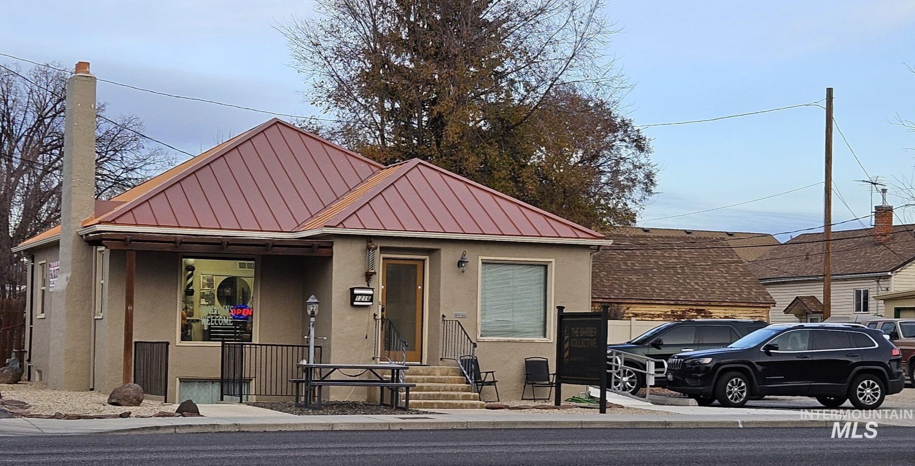 Bungalow-style house with stucco siding, a standing seam roof, and a metal roof
