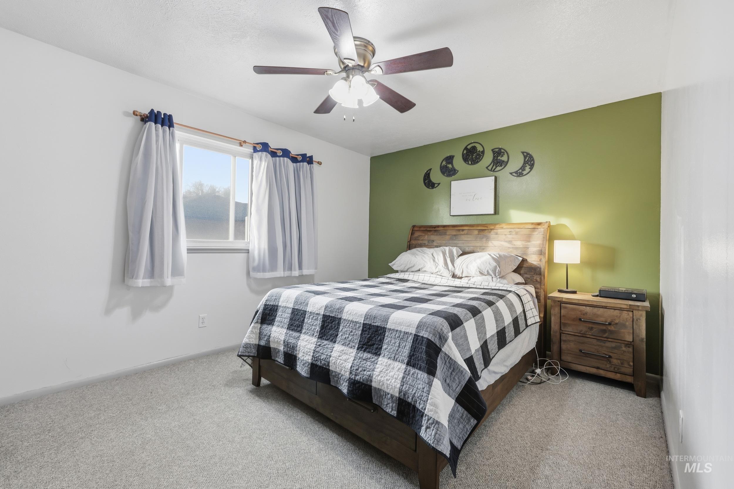 Bedroom featuring ceiling fan and carpet floors