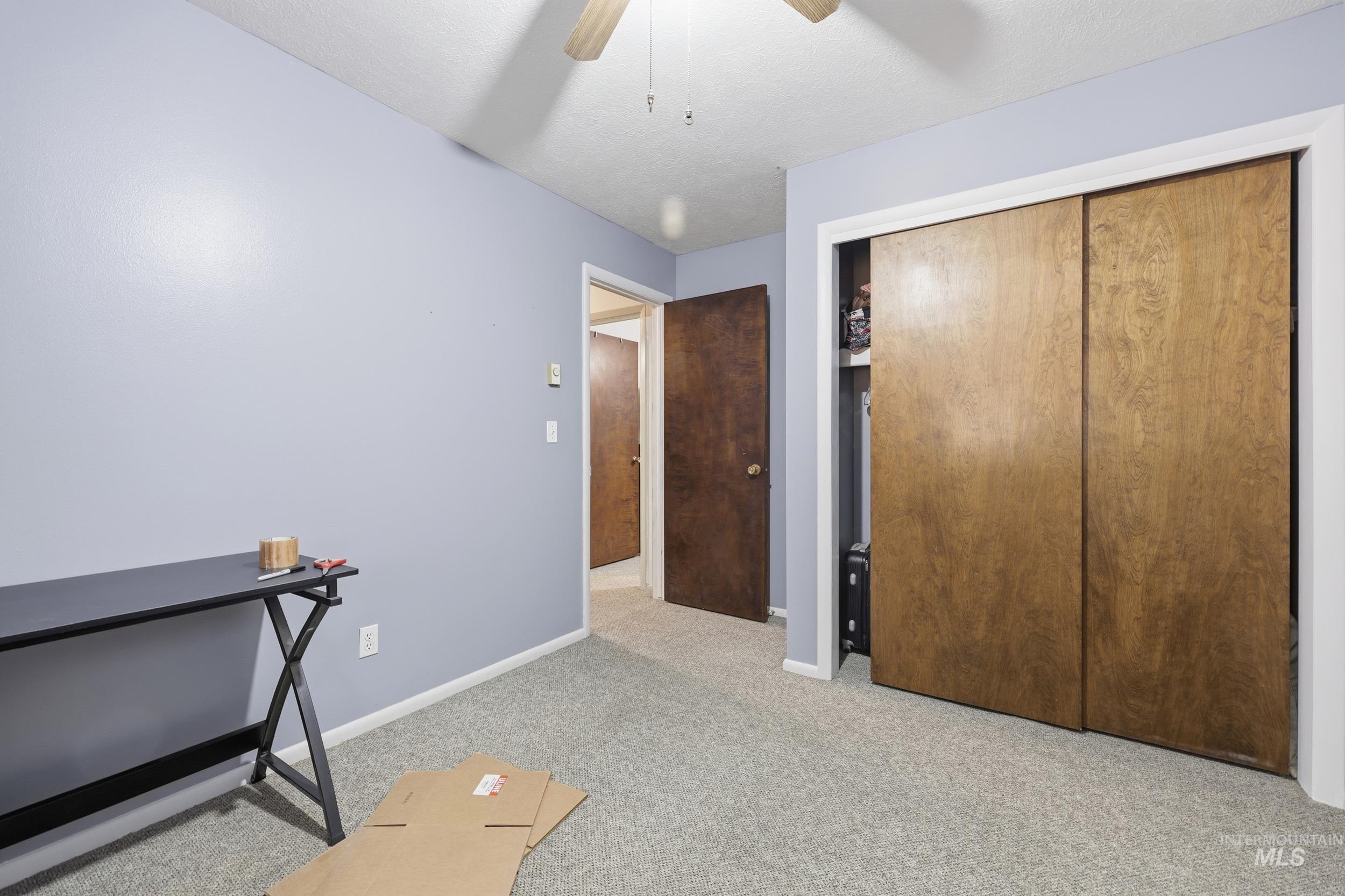 Bedroom featuring light colored carpet, a closet, and ceiling fan
