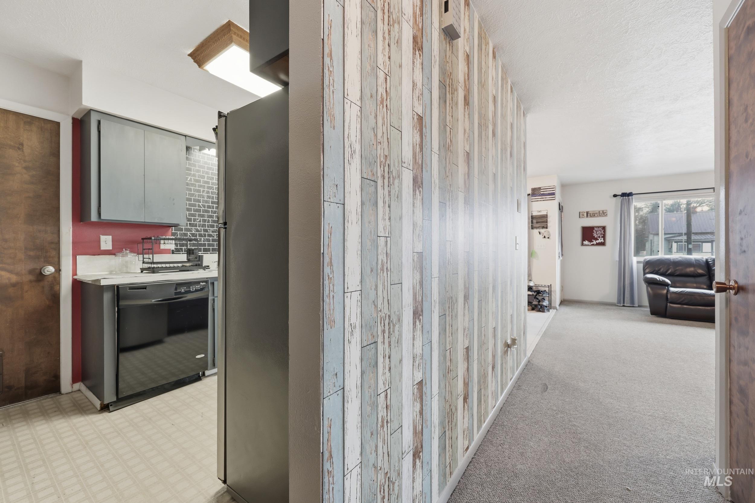 Hall featuring light floors, light carpet, and wood walls