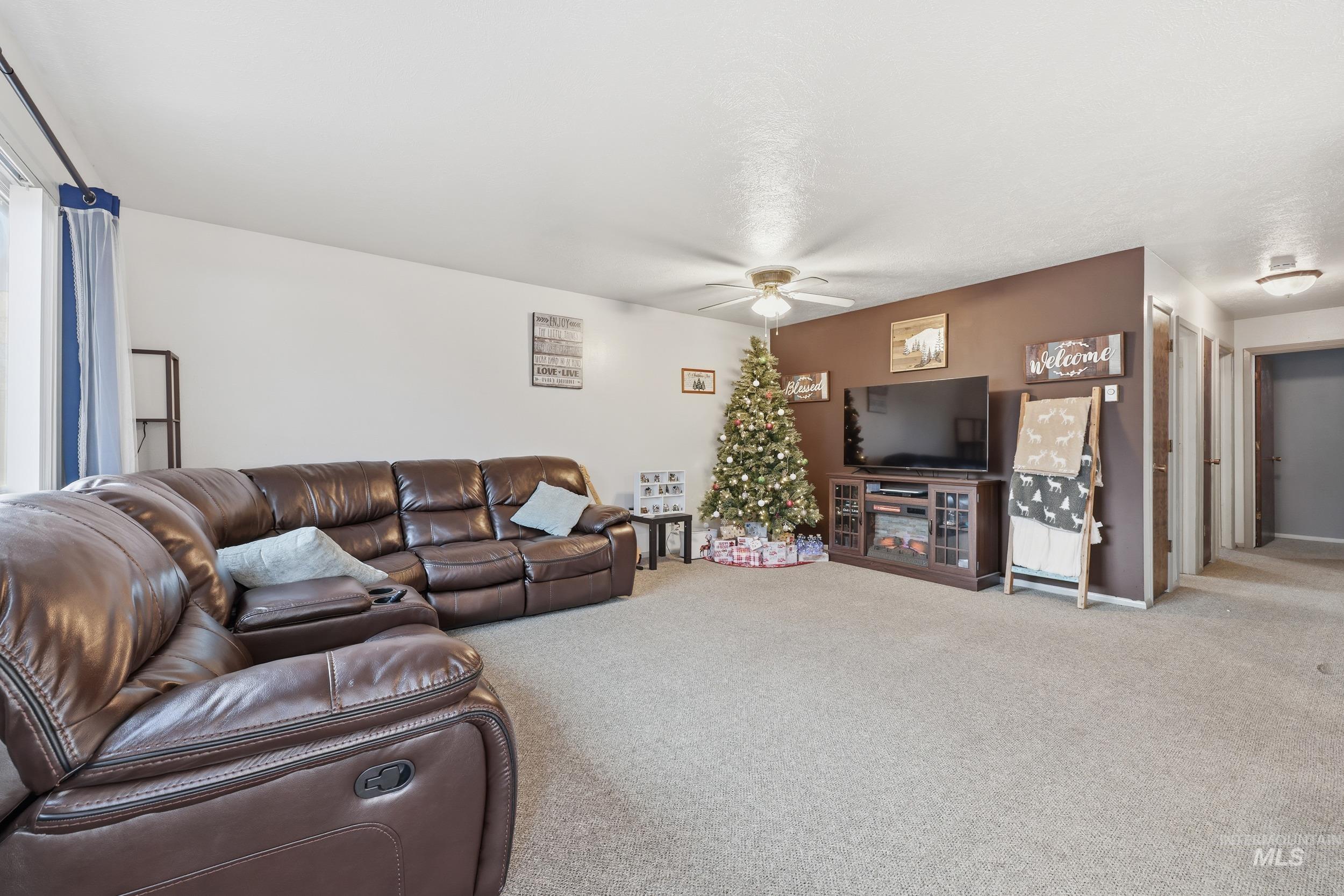 Carpeted living room featuring a ceiling fan