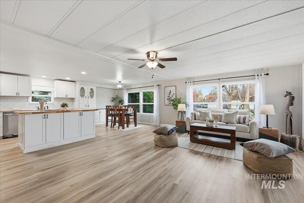 Living area with light wood-style flooring, a ceiling fan, and recessed lighting